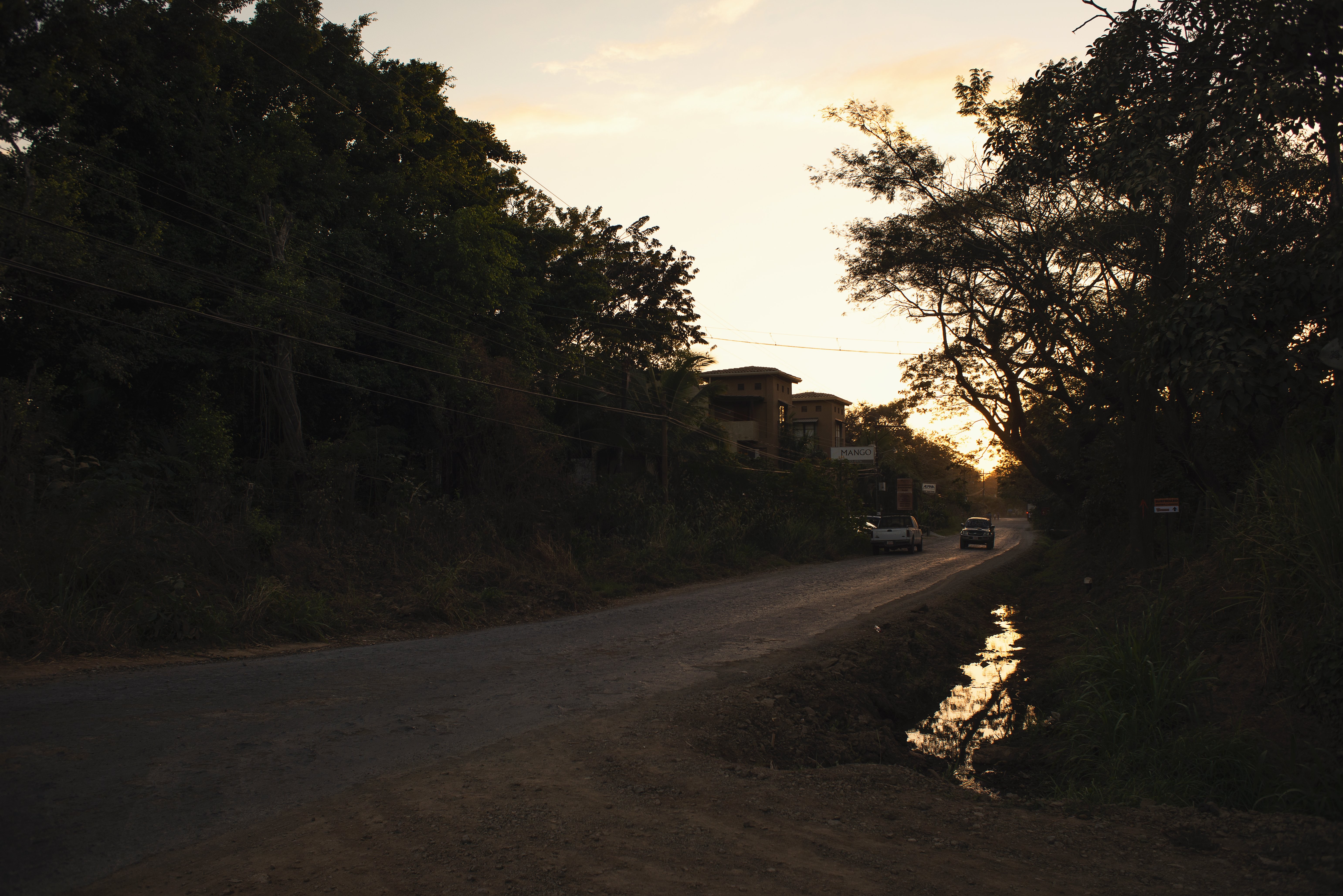 Foto de uma estrada de cascalho ao pôr do sol 