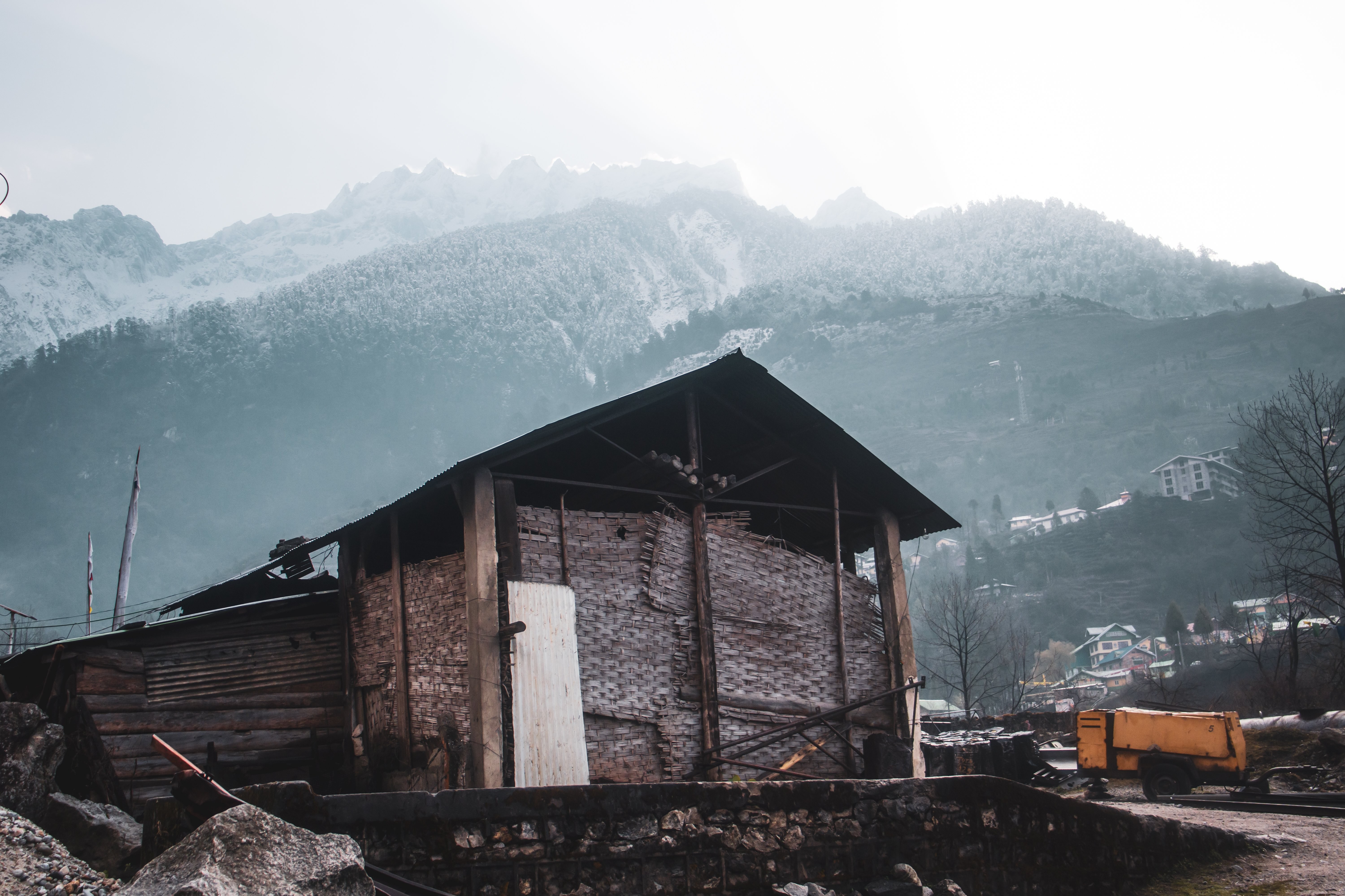 Edifício rústico com montanhas cobertas de neve atrás dele. Foto 