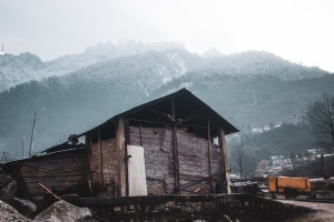 Edificio rústico con montañas nevadas detrás Foto 