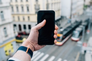 La main tend un téléphone portable noir avec un paysage flou Photo 