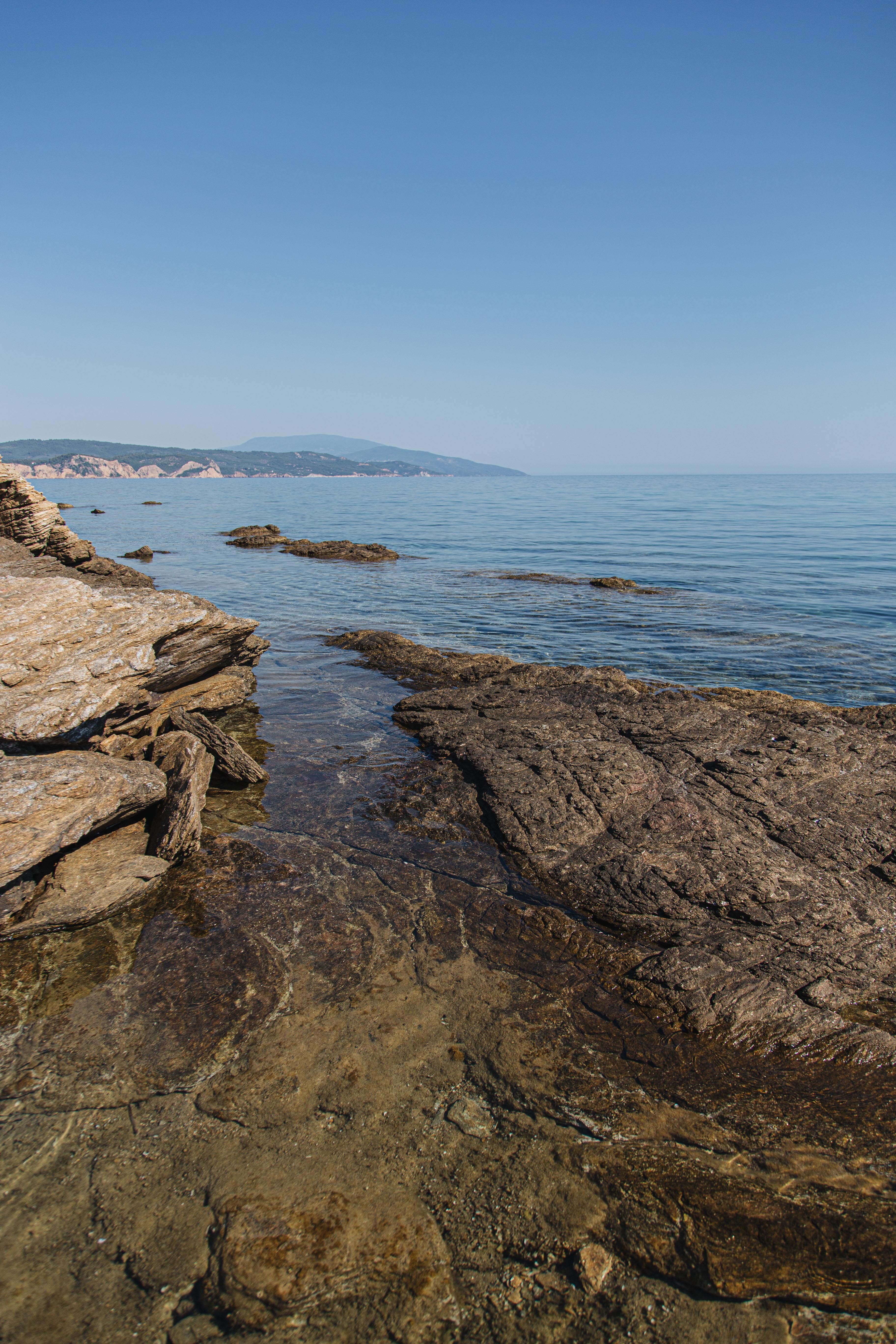 外洋と青空の写真と岩の多い海岸 
