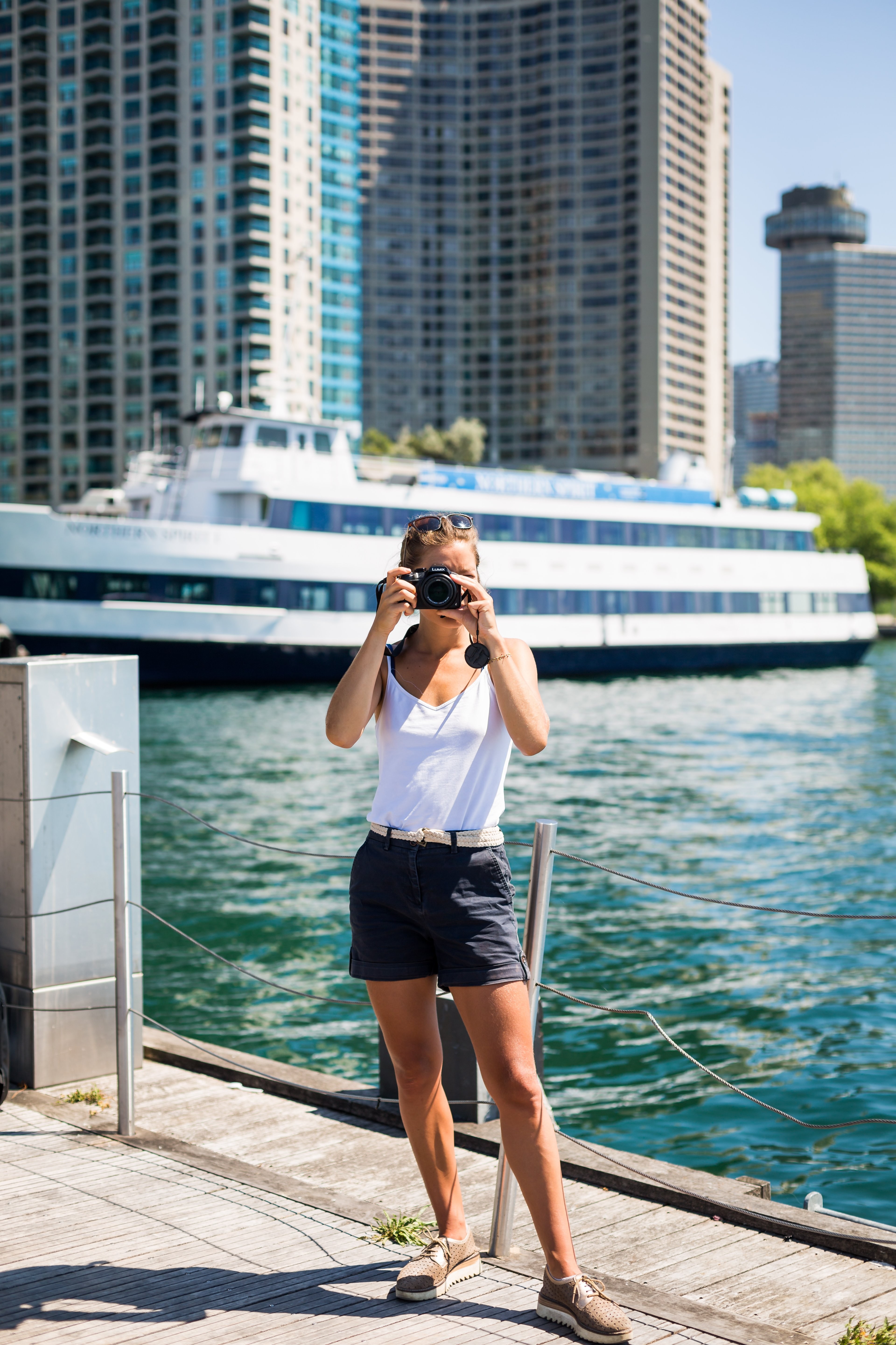 La persona se para frente al mar y sostiene la cámara para tomar una foto 