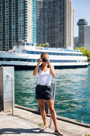 Pessoa fica de pé à beira-mar e segura a câmera para tirar uma foto 