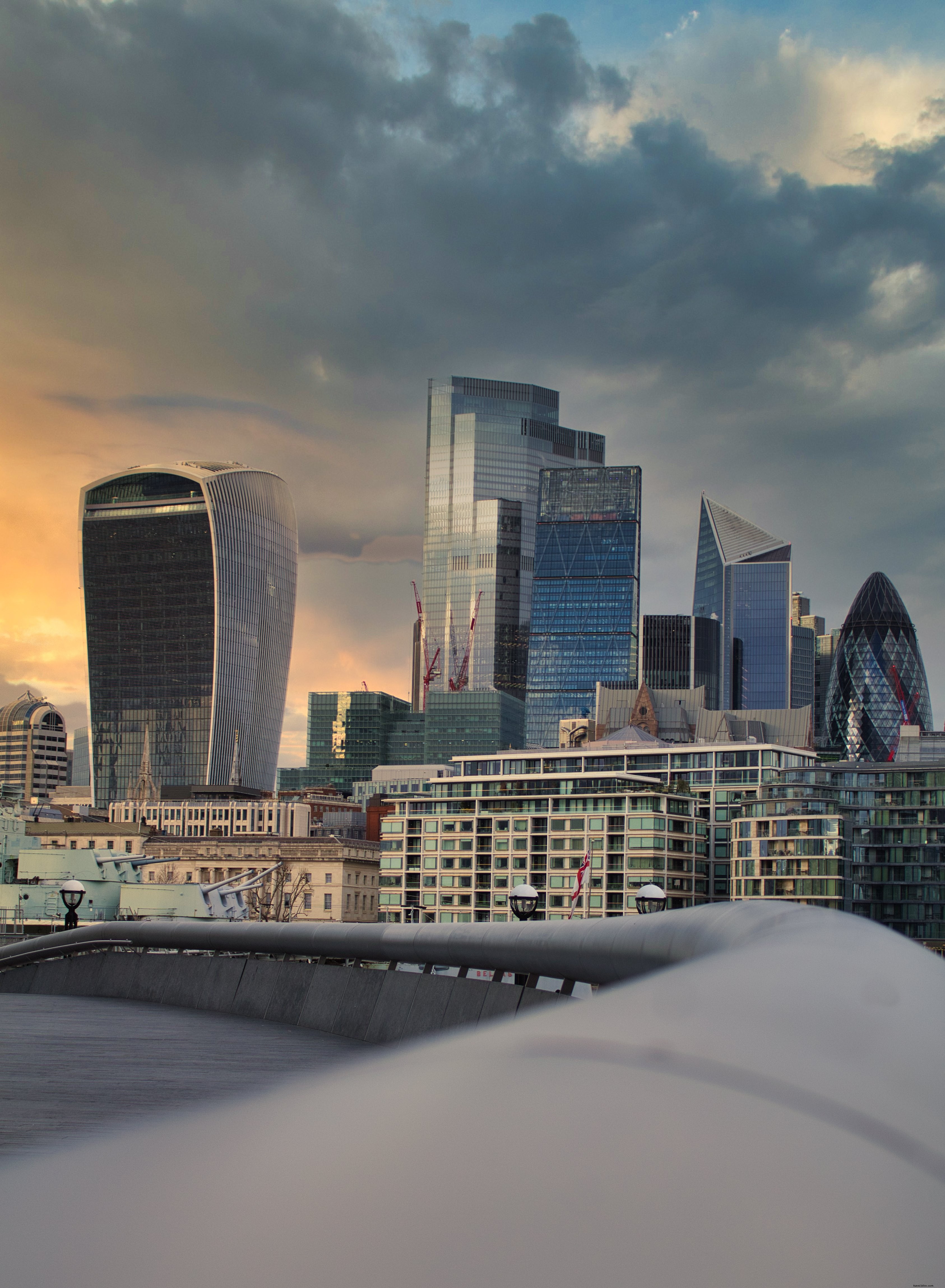 Paisagem urbana de Londres ao pôr do sol nublado com fotos de edifícios de vidro 