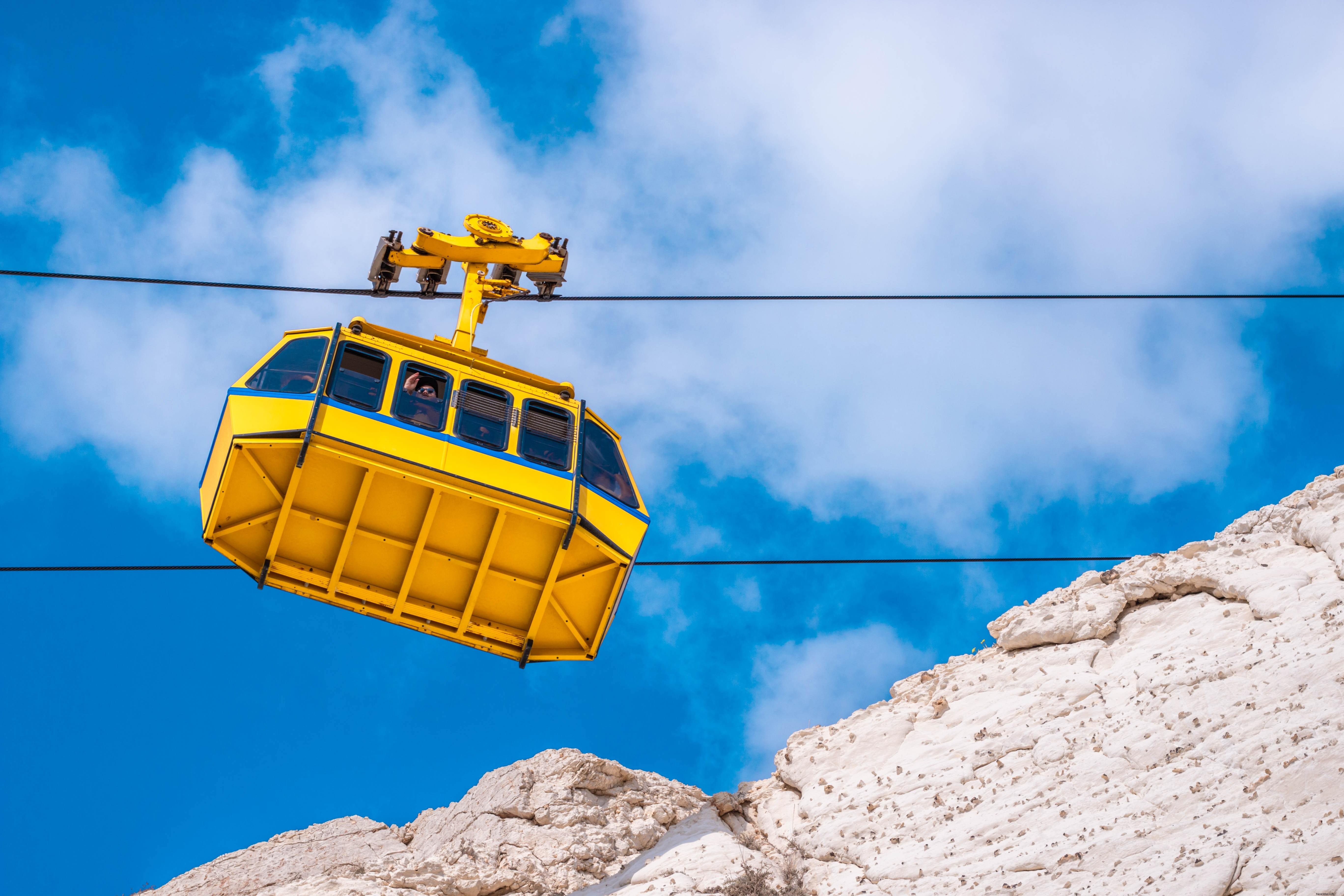 Foto de teleférico amarillo y montañas rocosas blancas 