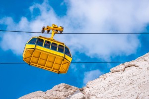 Foto de teleférico amarillo y montañas rocosas blancas 