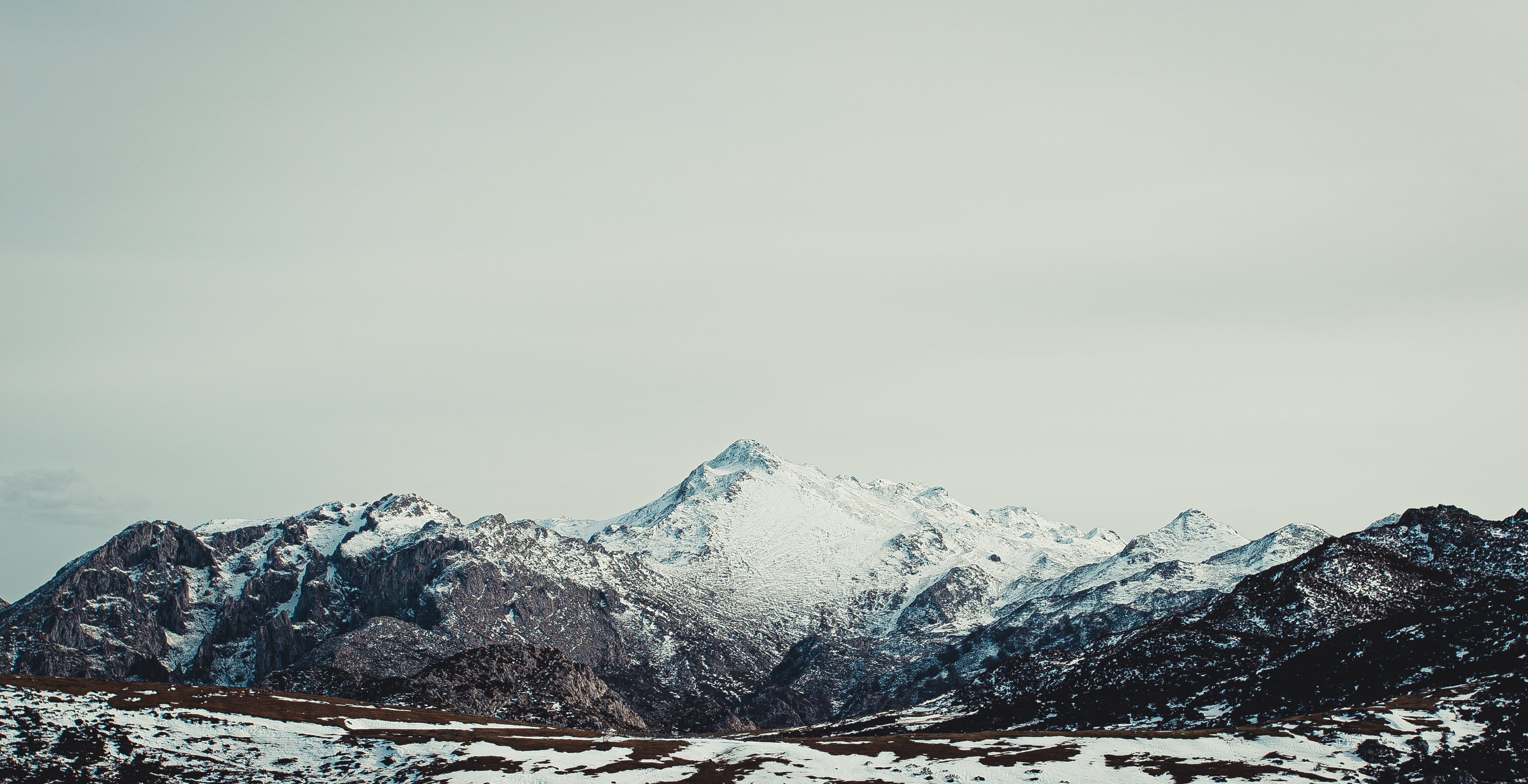 Vasta montaña nevada bajo el cielo gris Foto 