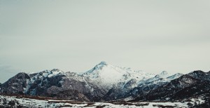 Foto de uma vasta montanha coberta de neve sob o céu cinza 