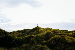 Foto de mujer camina por dunas cubiertas de hierba 