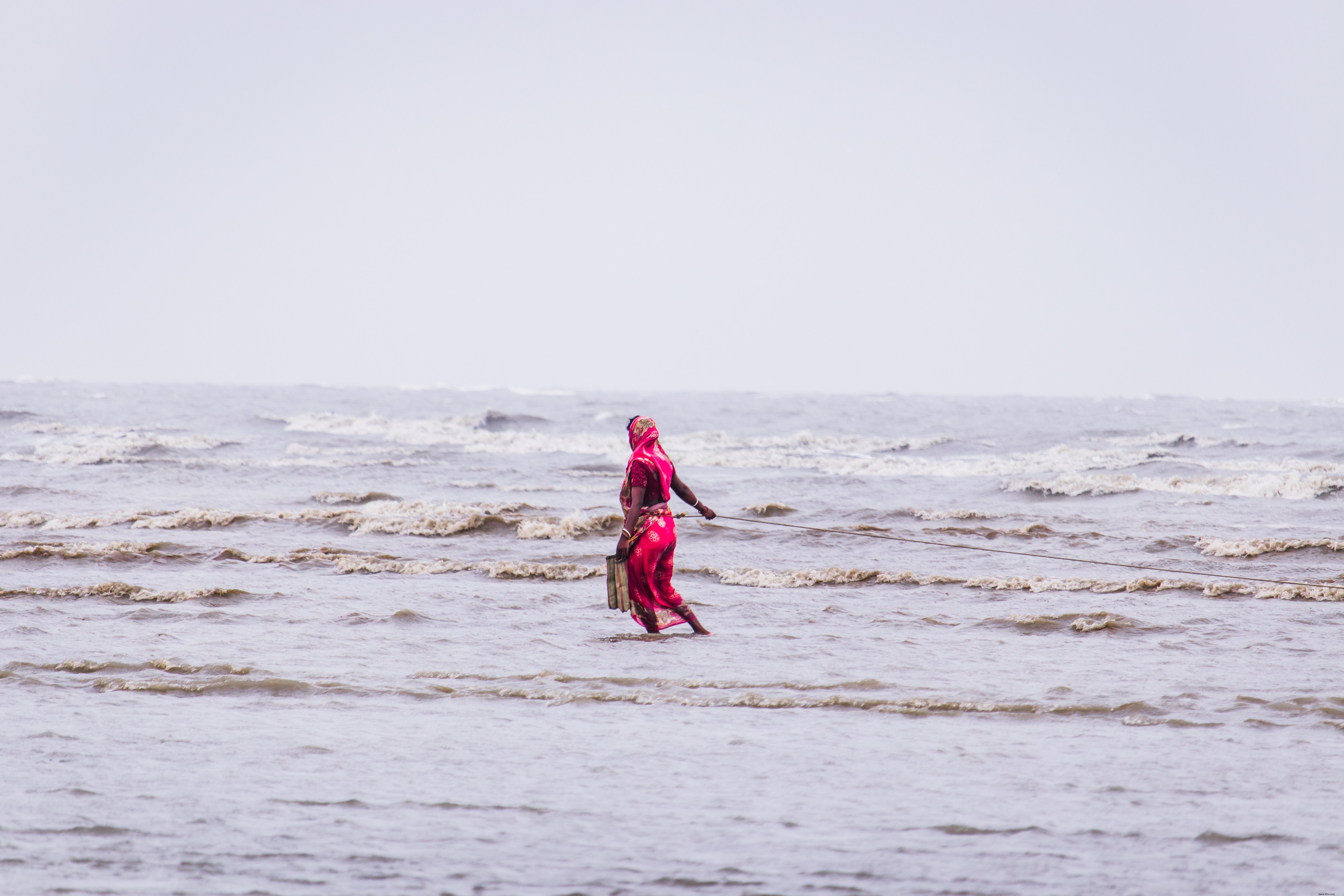 Mulher de vermelho andando em água rasa foto 