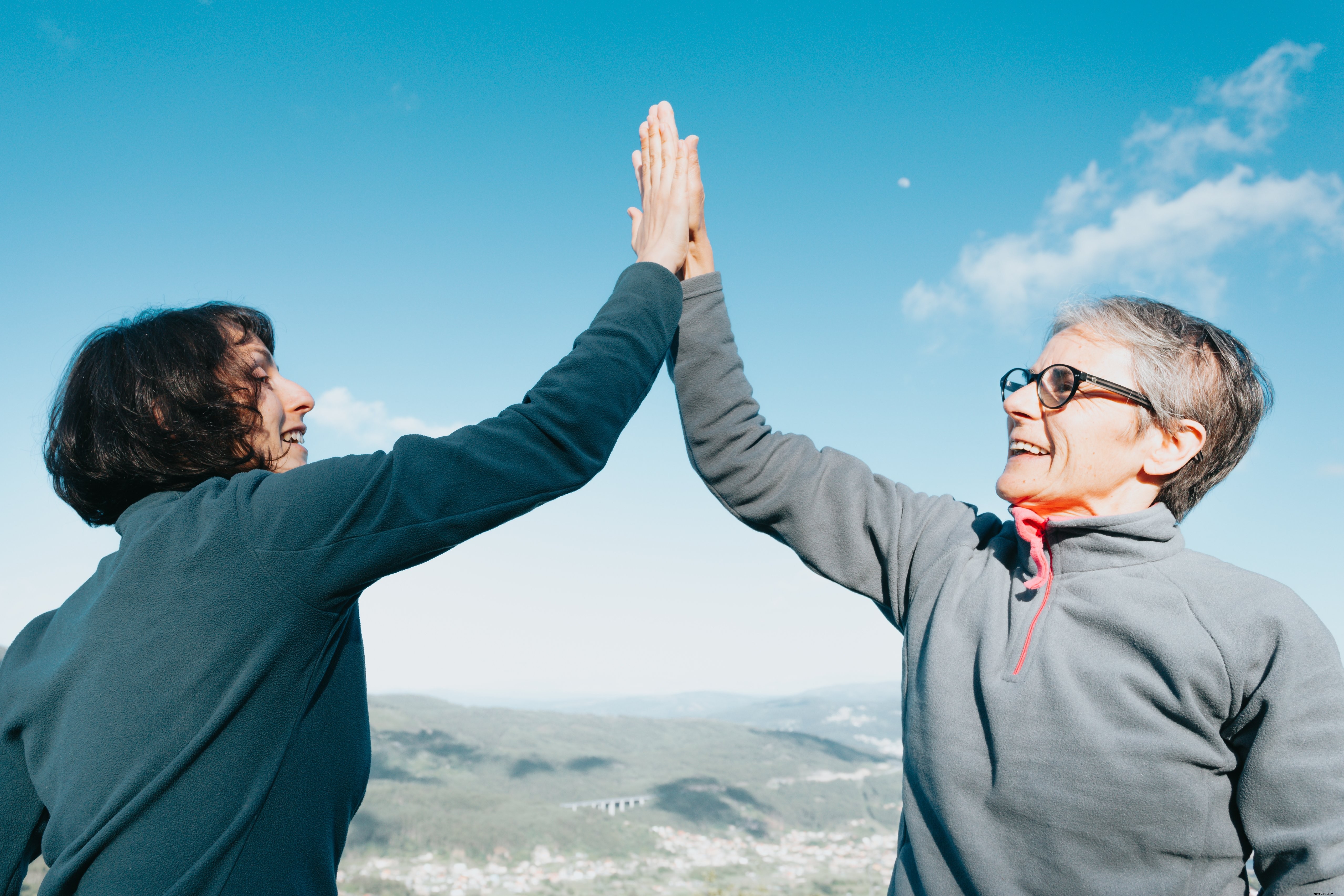 Due donne che danno il cinque sotto il cielo blu foto 