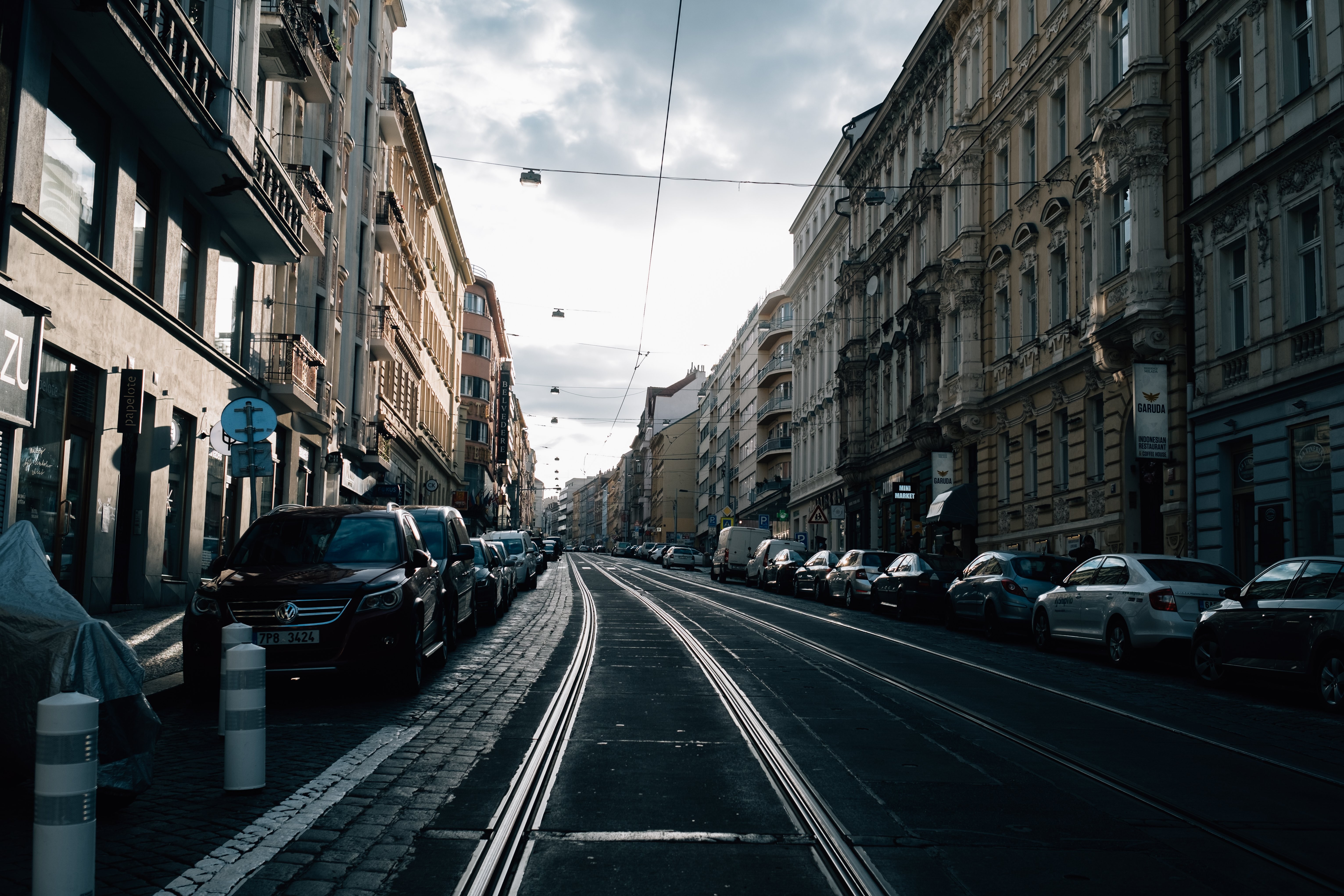 Auto parcheggiate in fila per una strada di città vuota Foto 