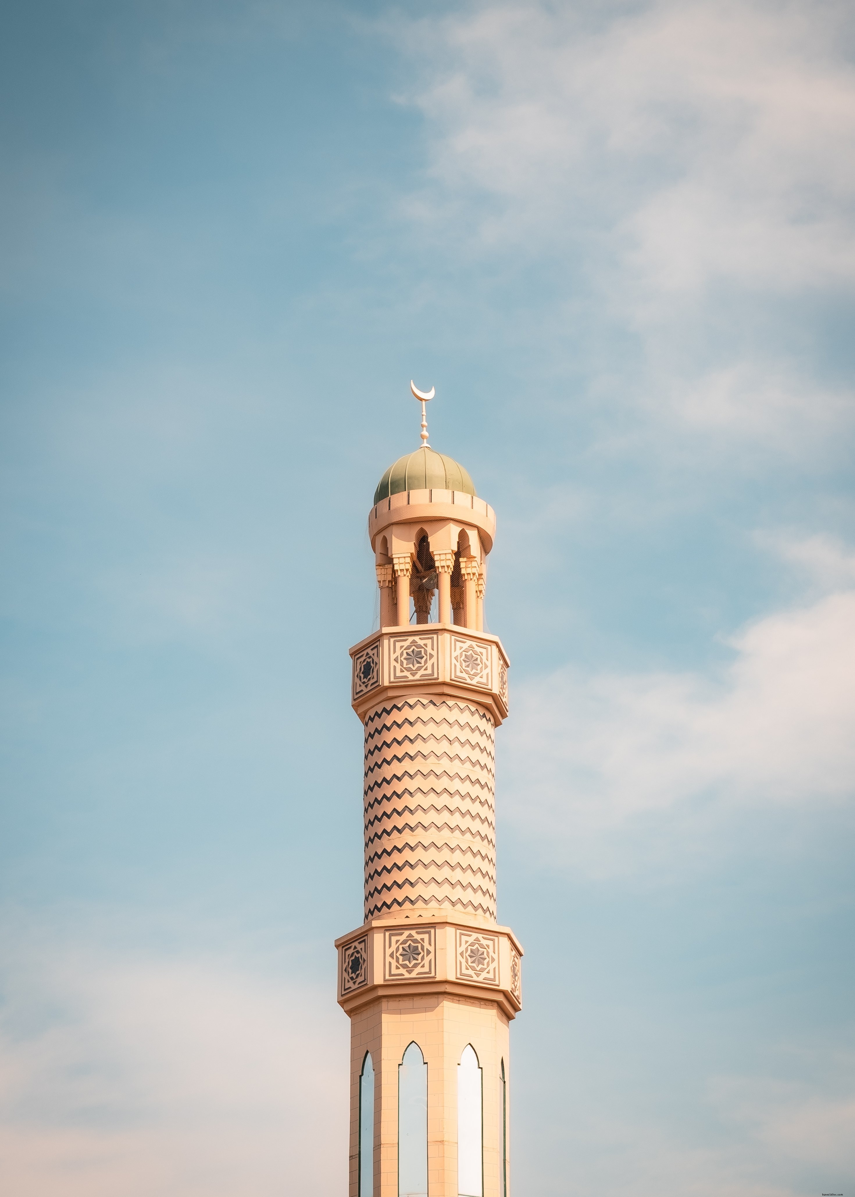 Torre alta e sottile con un tetto rotondo contro un cielo blu foto 