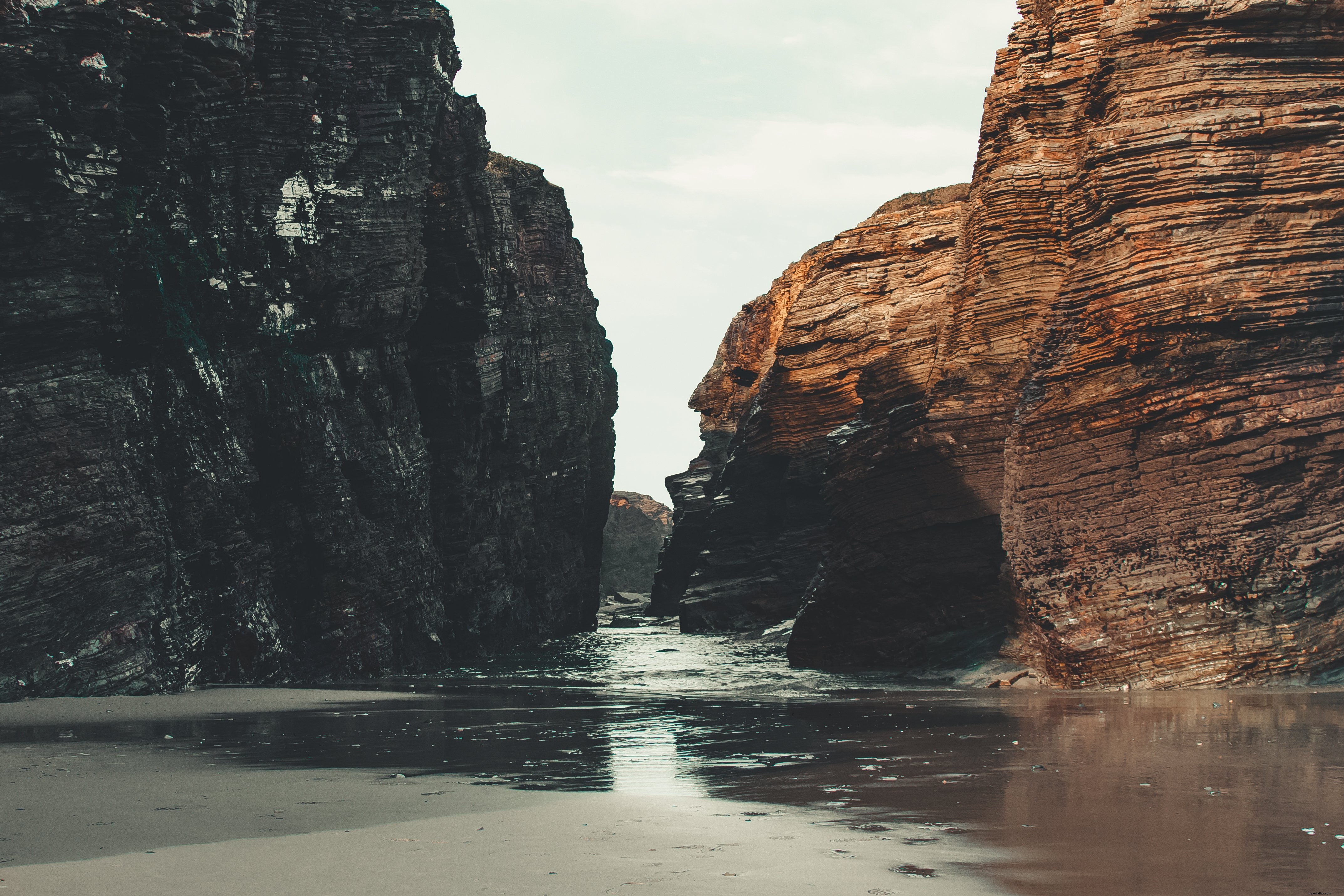 Foto da maré rolando para a costa entre as rochas 