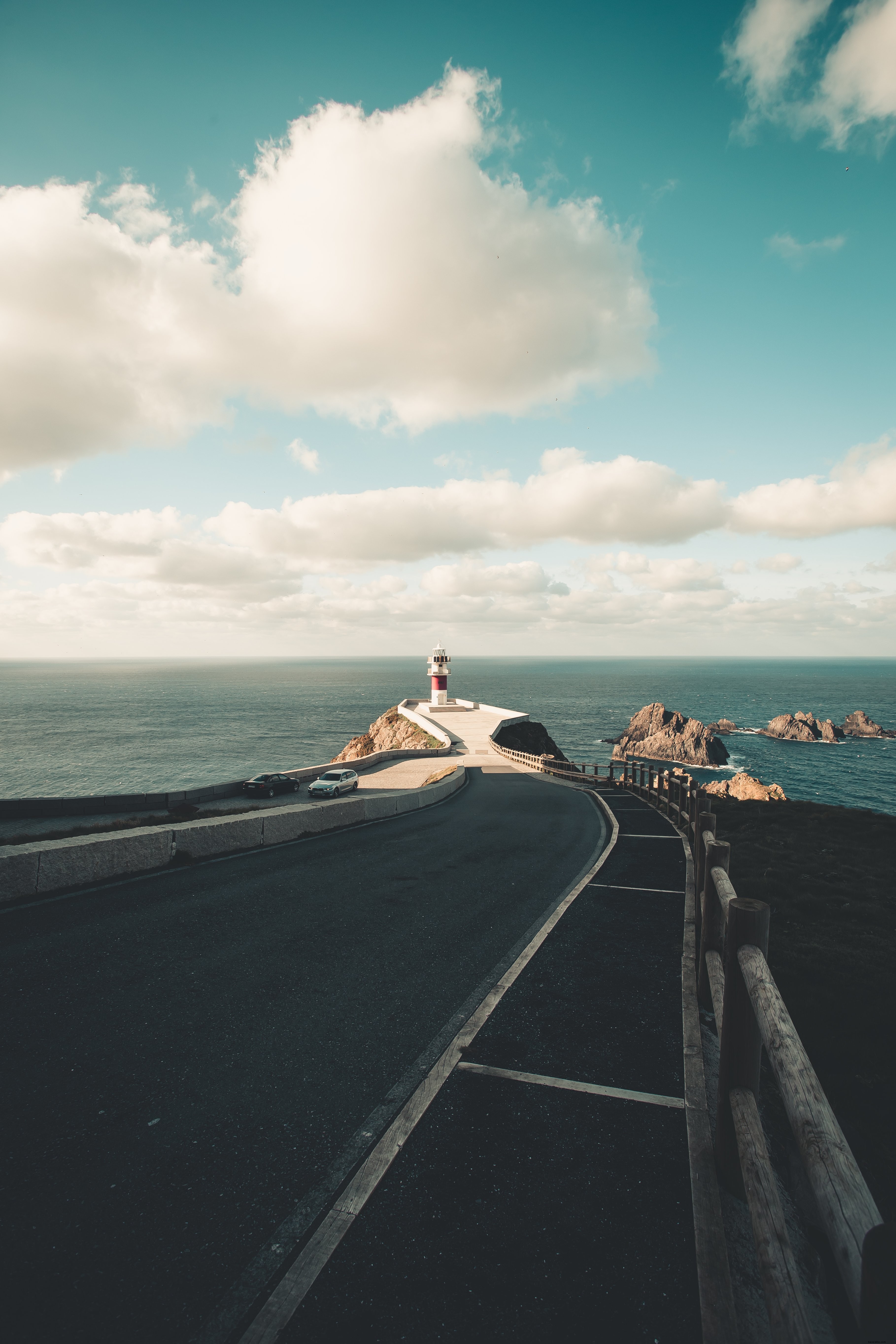 Foto de estrada pavimentada que leva ao farol à beira-mar 