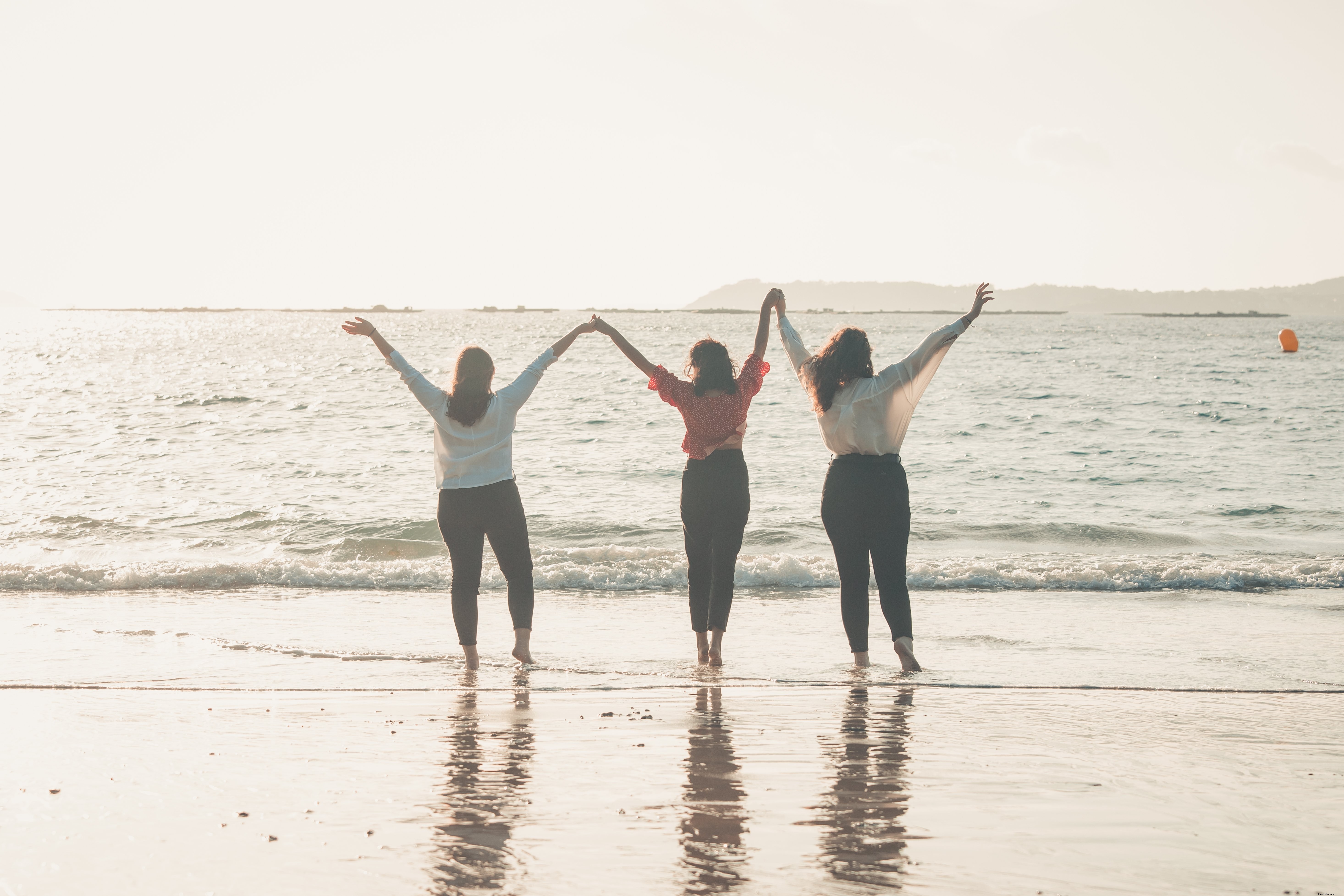 Tres personas se dan la mano con los brazos hacia el cielo Foto 