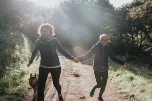 Le donne si tengono per mano mentre percorrono un sentiero Foto 