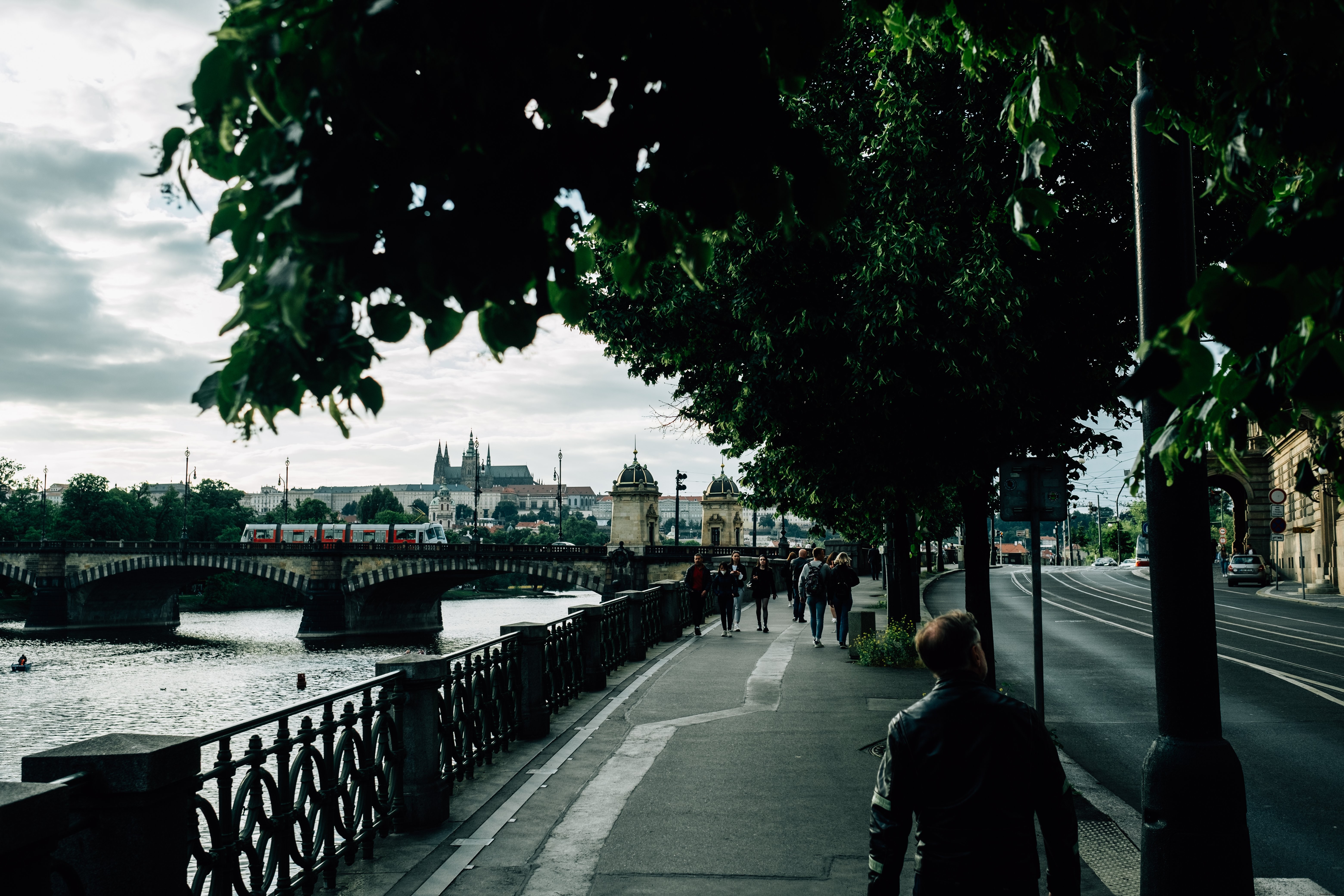 Les gens qui marchent sur un trottoir bordé d arbres par une rivière Photo 