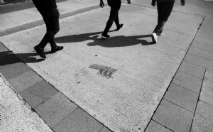 Jambes de trois personnes marchant en photo noir et blanc 