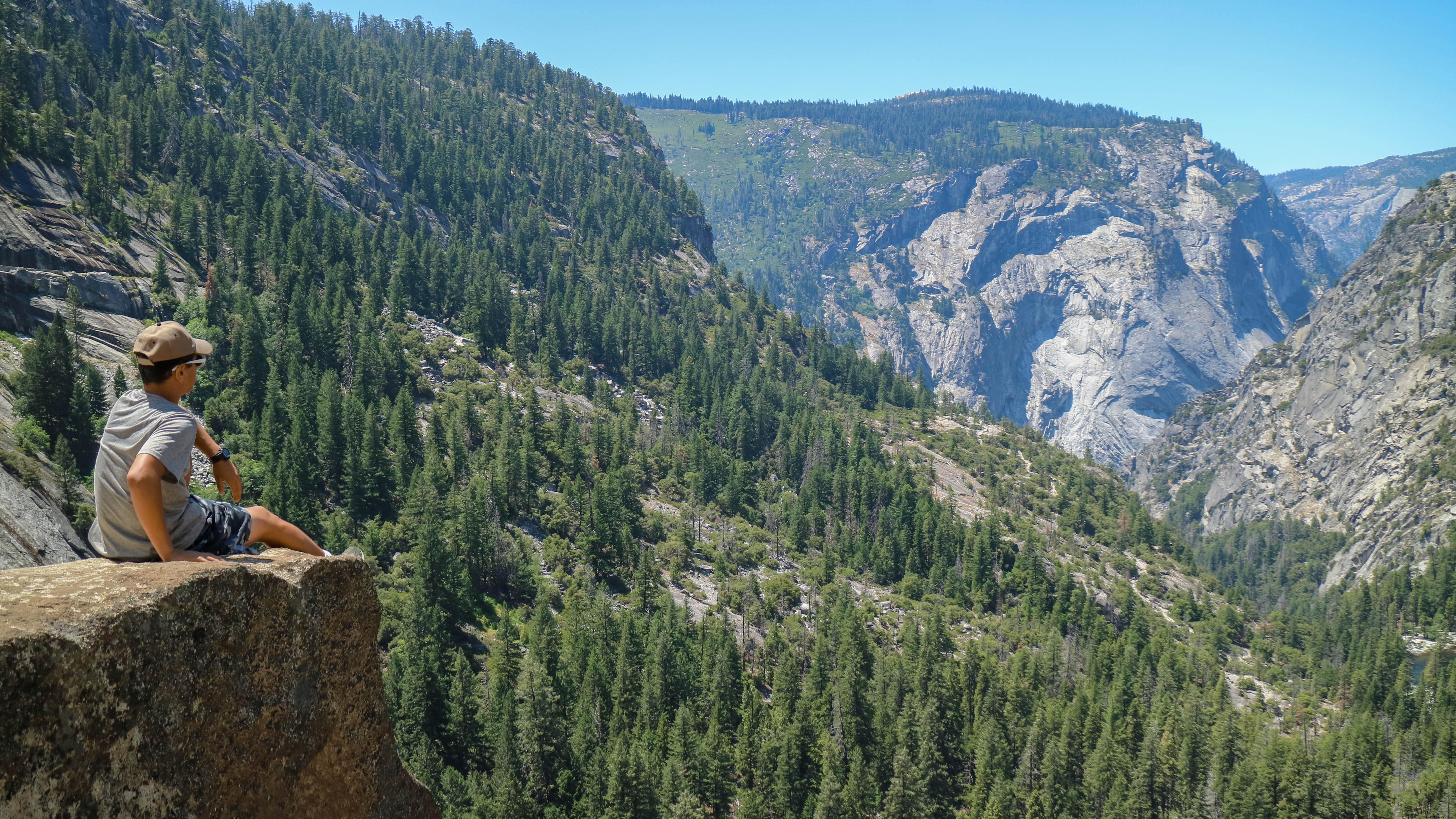 Assis sur le rebord en regardant les montagnes et les arbres Photo 