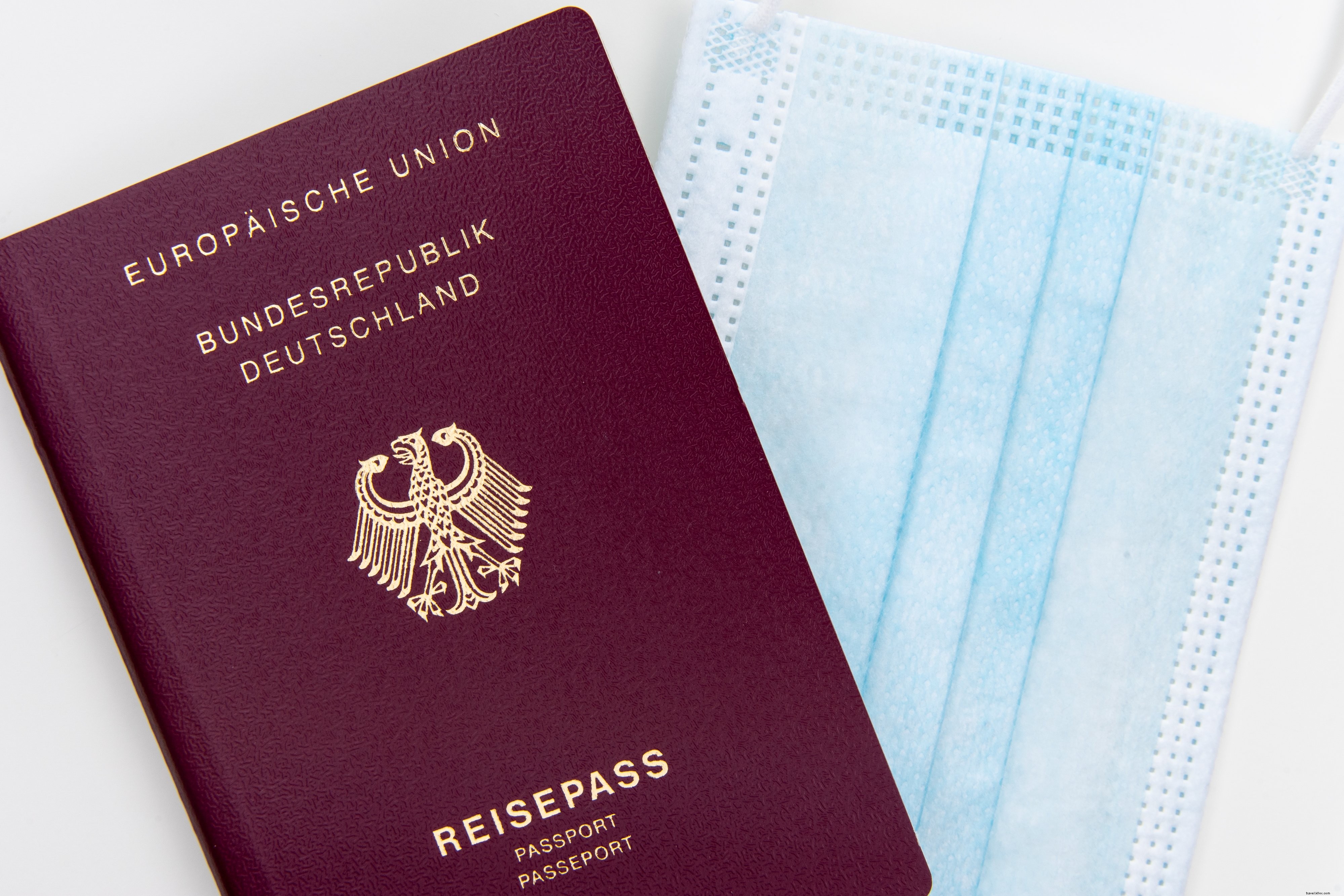 Flatlay de un pasaporte y una foto de mascarilla desechable 