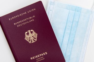 Flatlay de un pasaporte y una foto de mascarilla desechable 