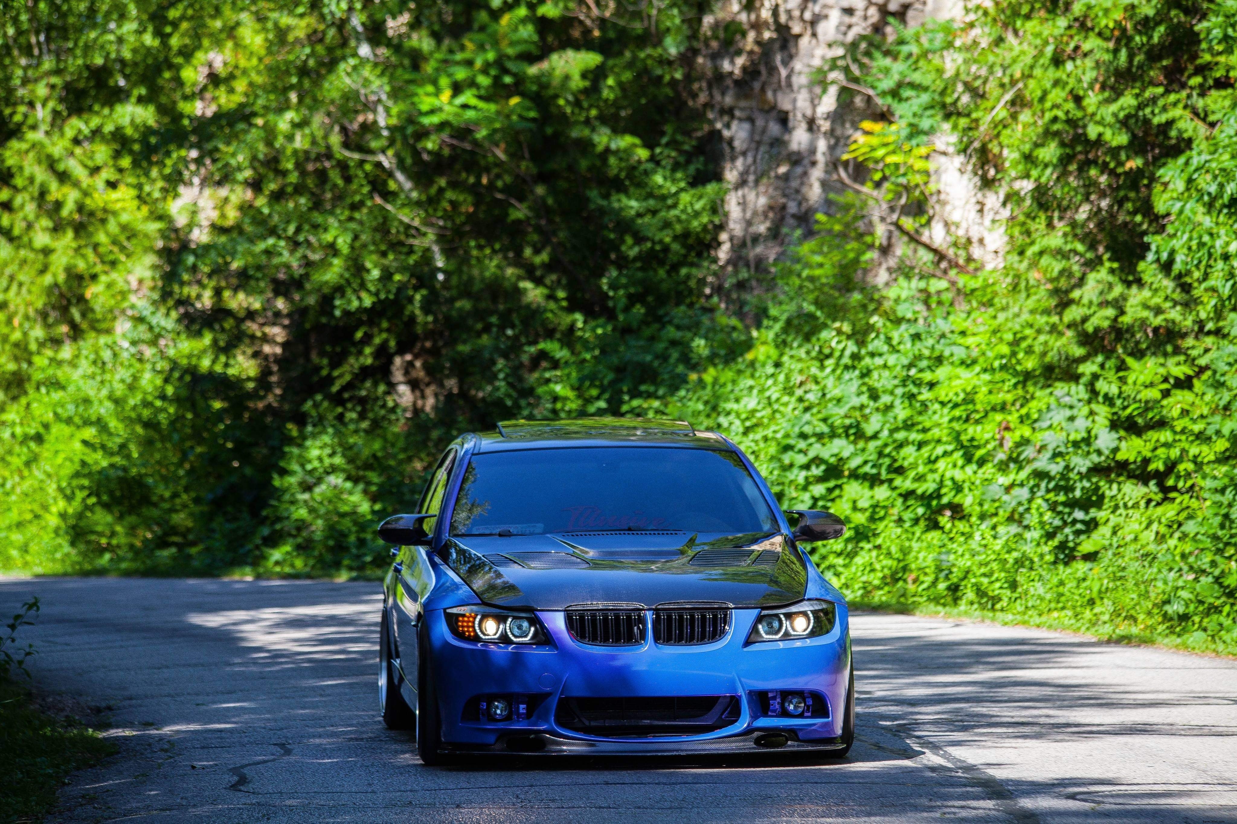 Voiture de sport bleue roule le long de la route de campagne Photo 