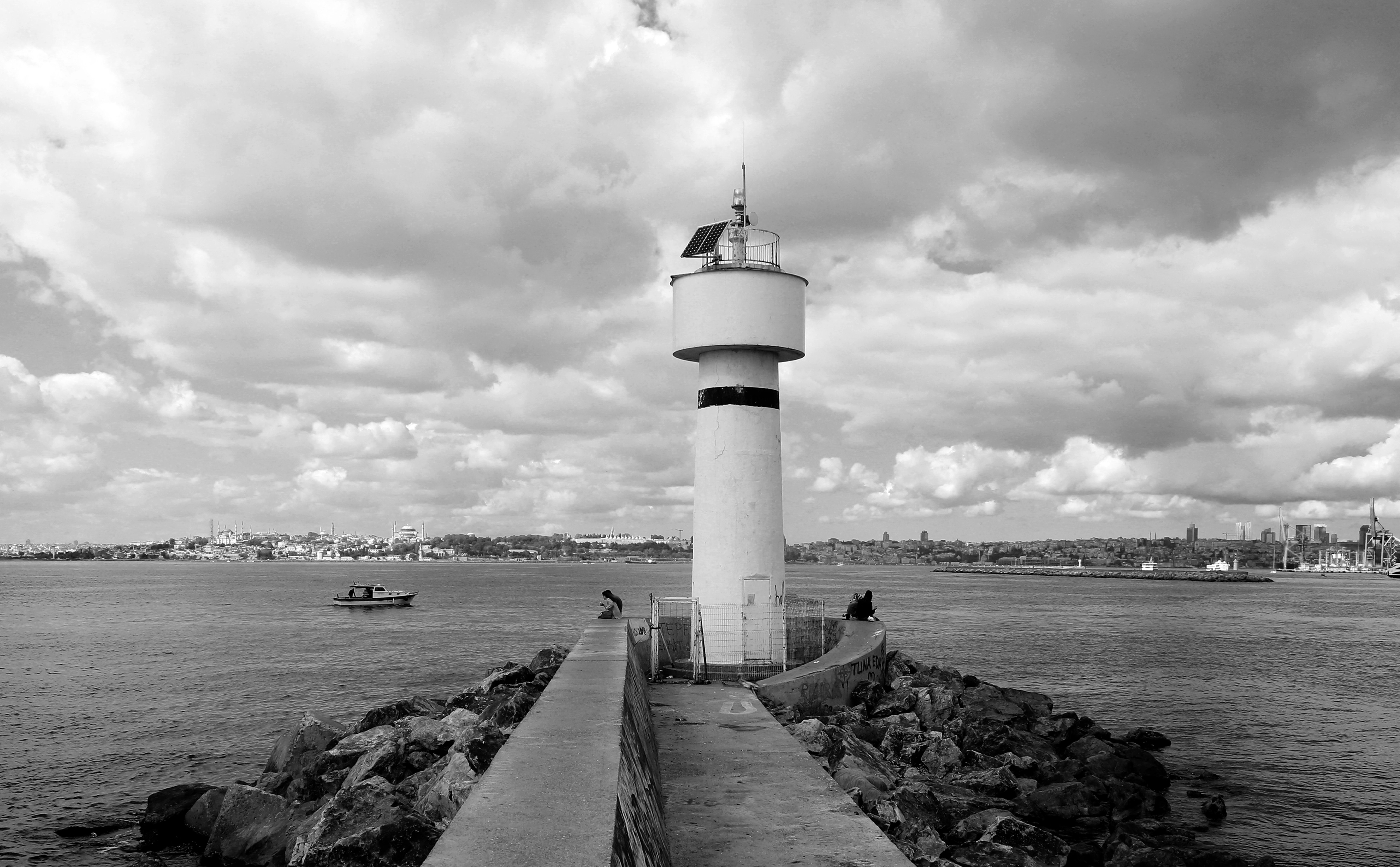 Faro in bianco e nero che si affaccia sull acqua calma foto 