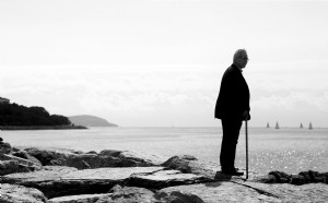 Homme monochrome debout seul regardant au-delà de la photo du rivage 