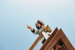 Femme sur une terrasse en bois pointe vers quelque chose hors du cadre photo 