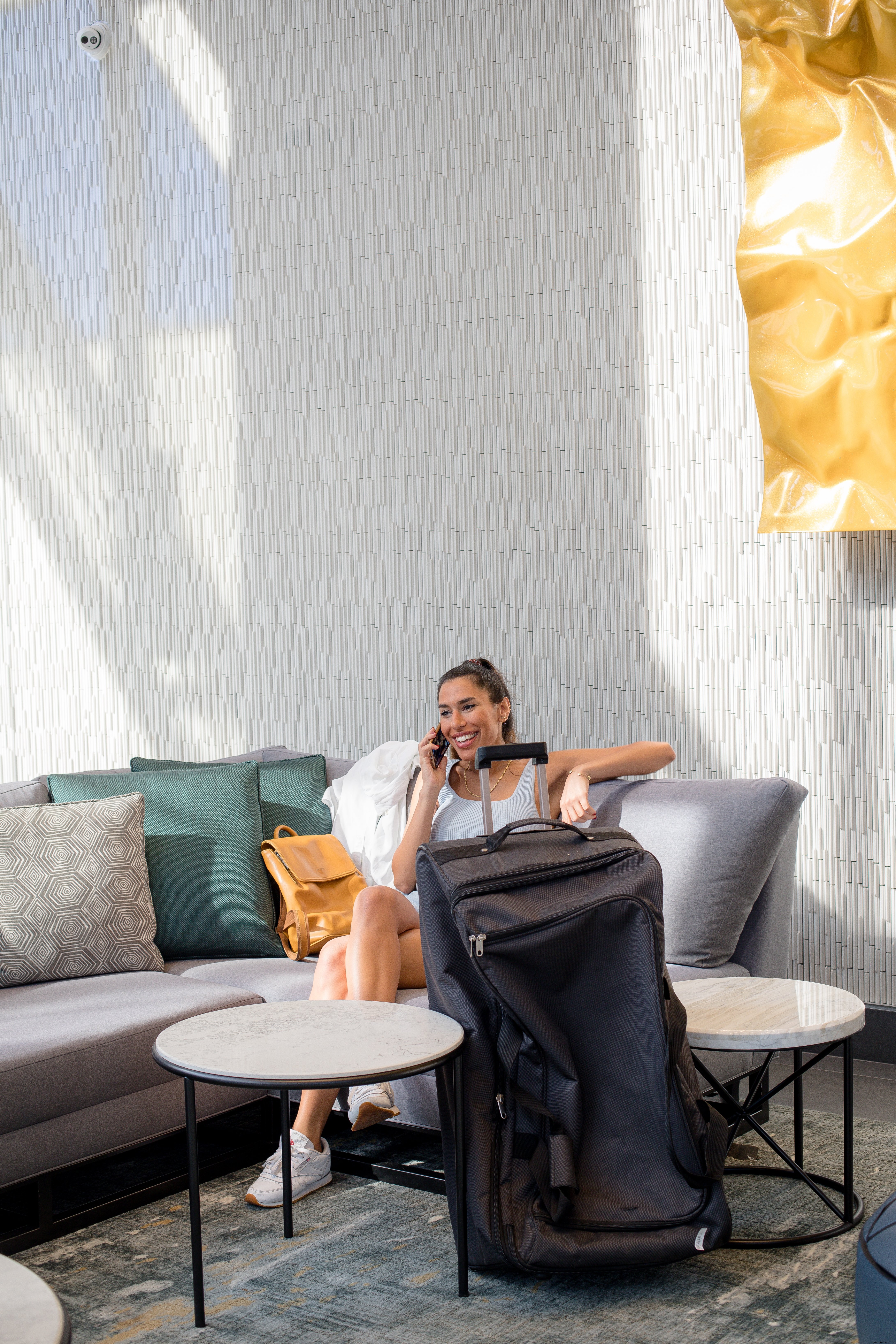 Femme parle sur son téléphone portable à côté de sa photo de bagages 