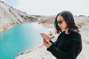 Une femme regarde son téléphone portable au bord de l eau bleue Photo 