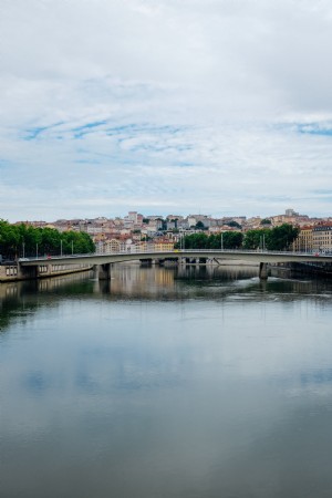 Vista de una ciudad y un puente moderno desde la fotografía de aguas tranquilas 