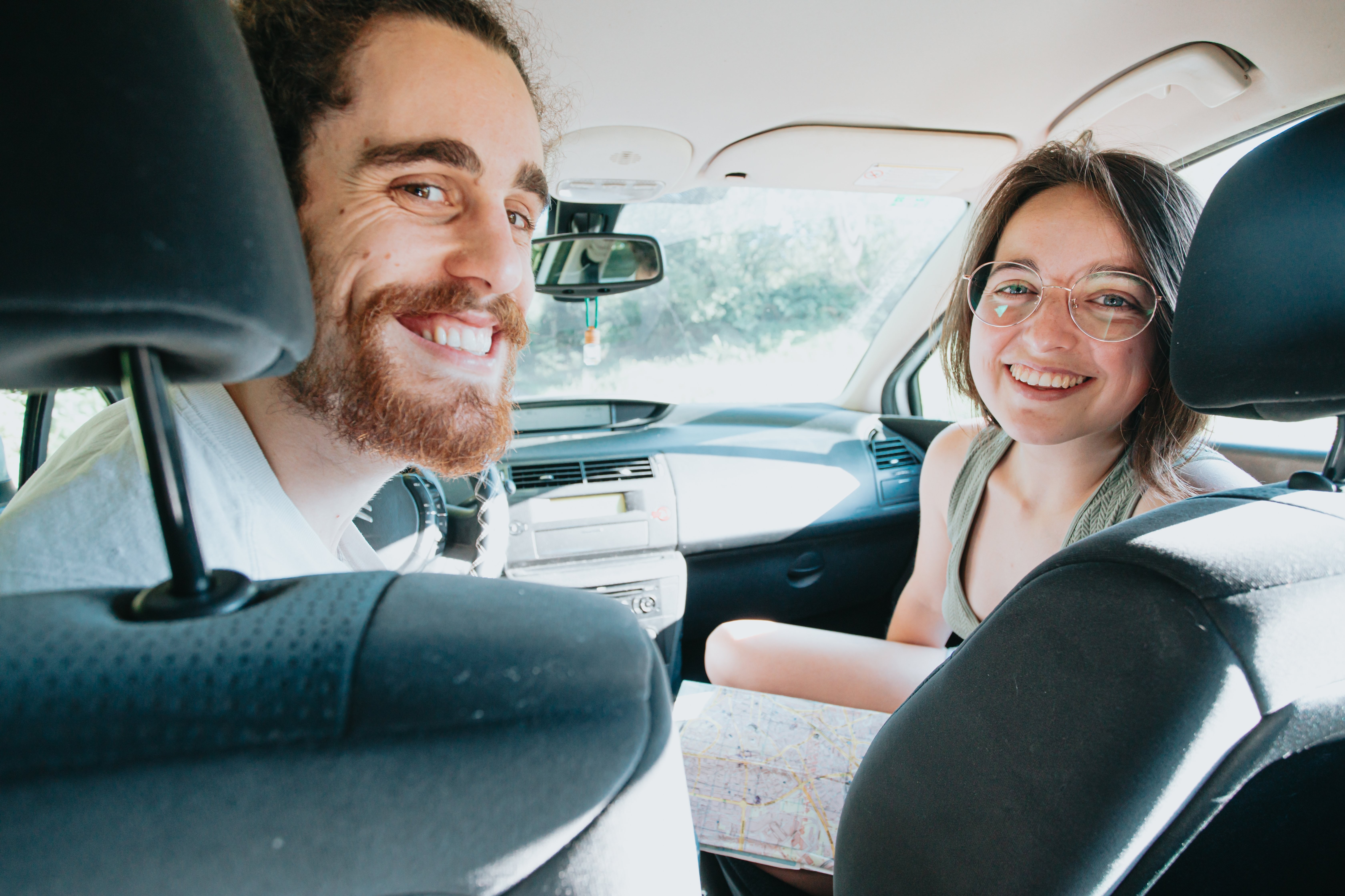 Duas pessoas em um carro, olhando para trás e sorrindo, foto 