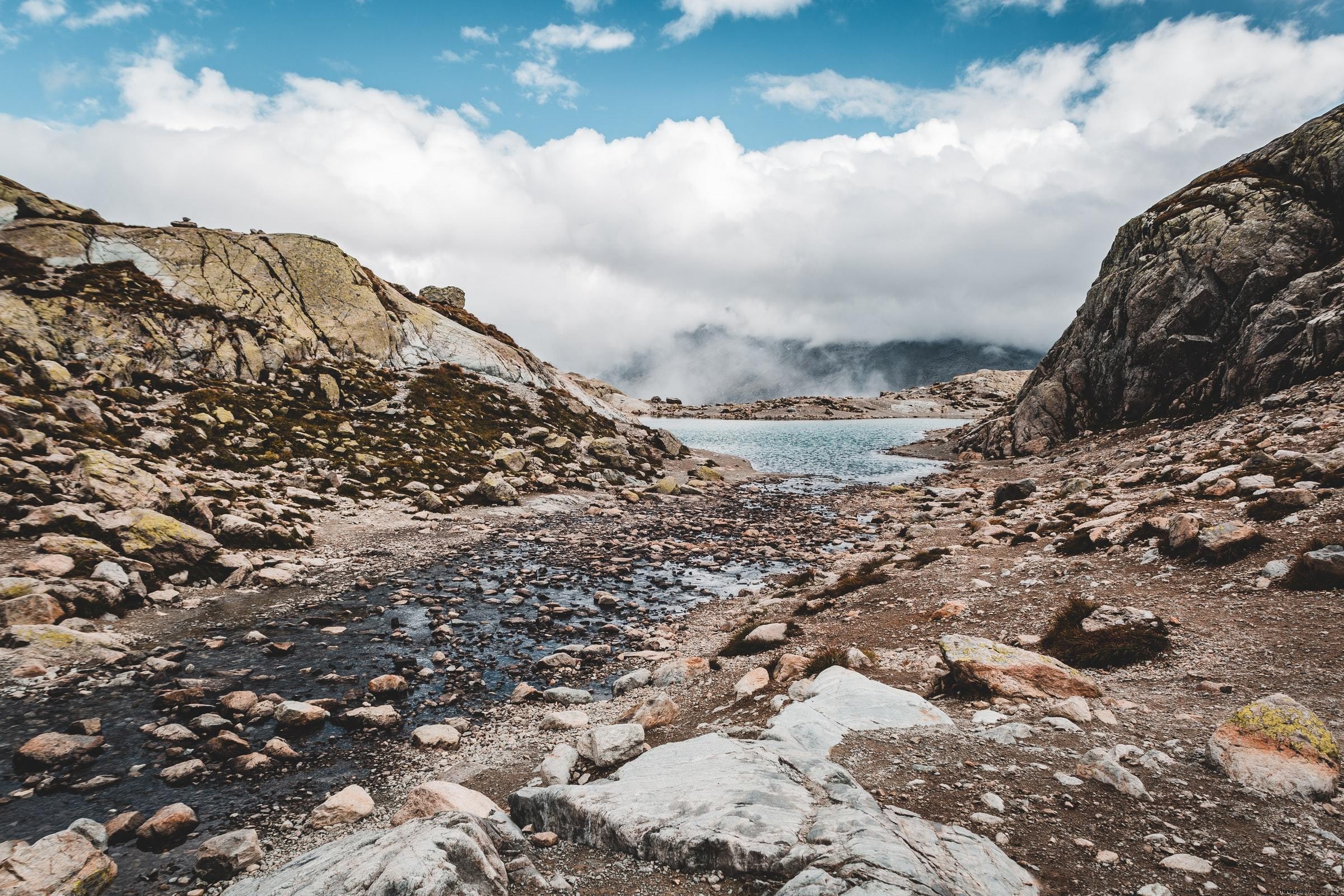 Água azul e a costa rochosa abaixo de nuvens baixas. Foto 