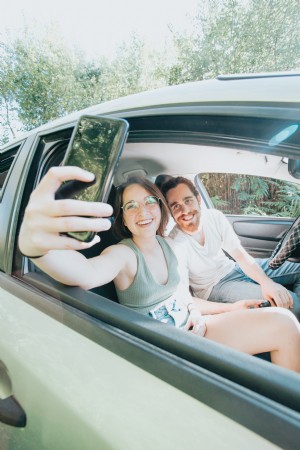 Deux personnes assises dans une voiture prennent ensemble une photo de selfie 