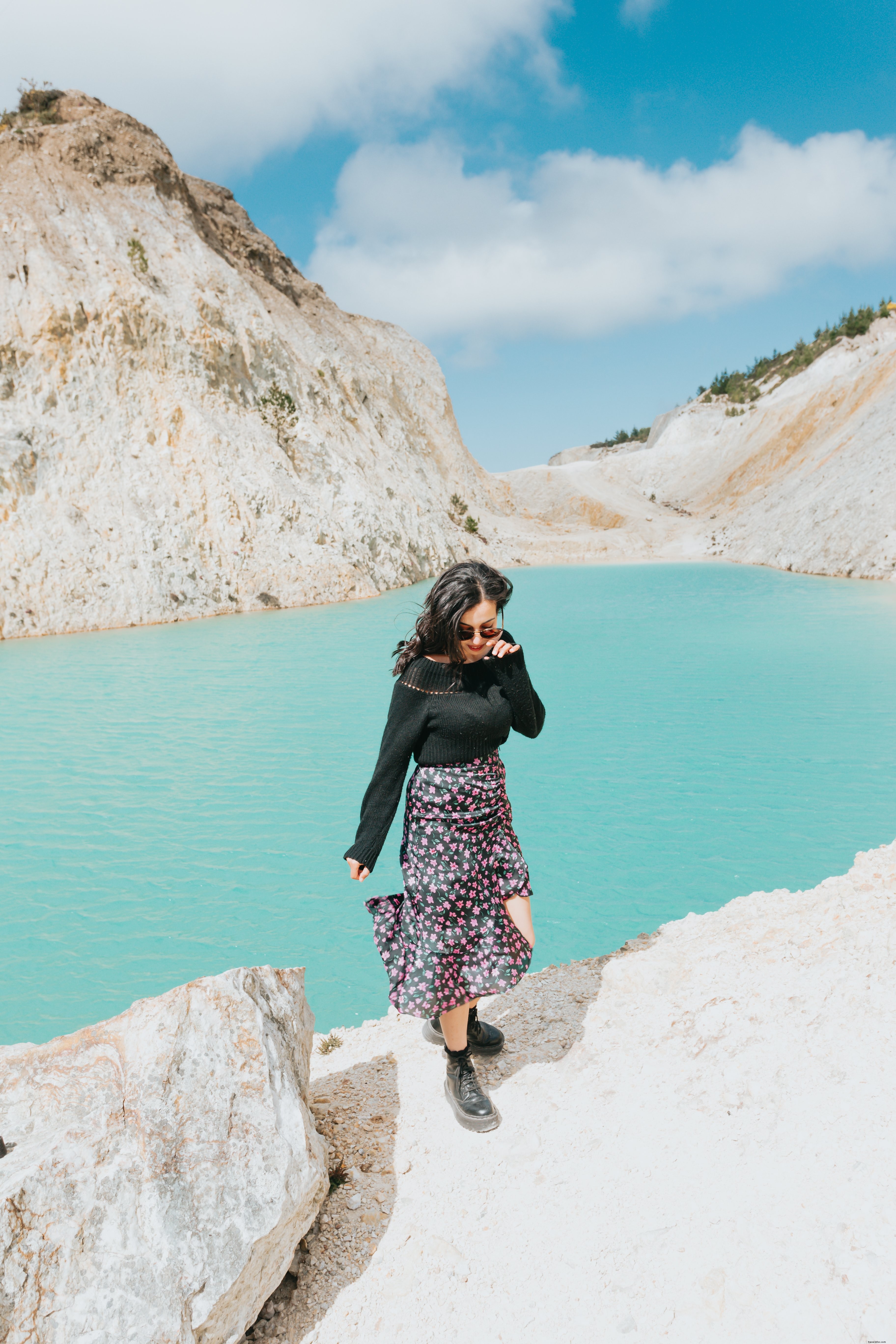 Donna cammina verso la telecamera da un lago blu foto 