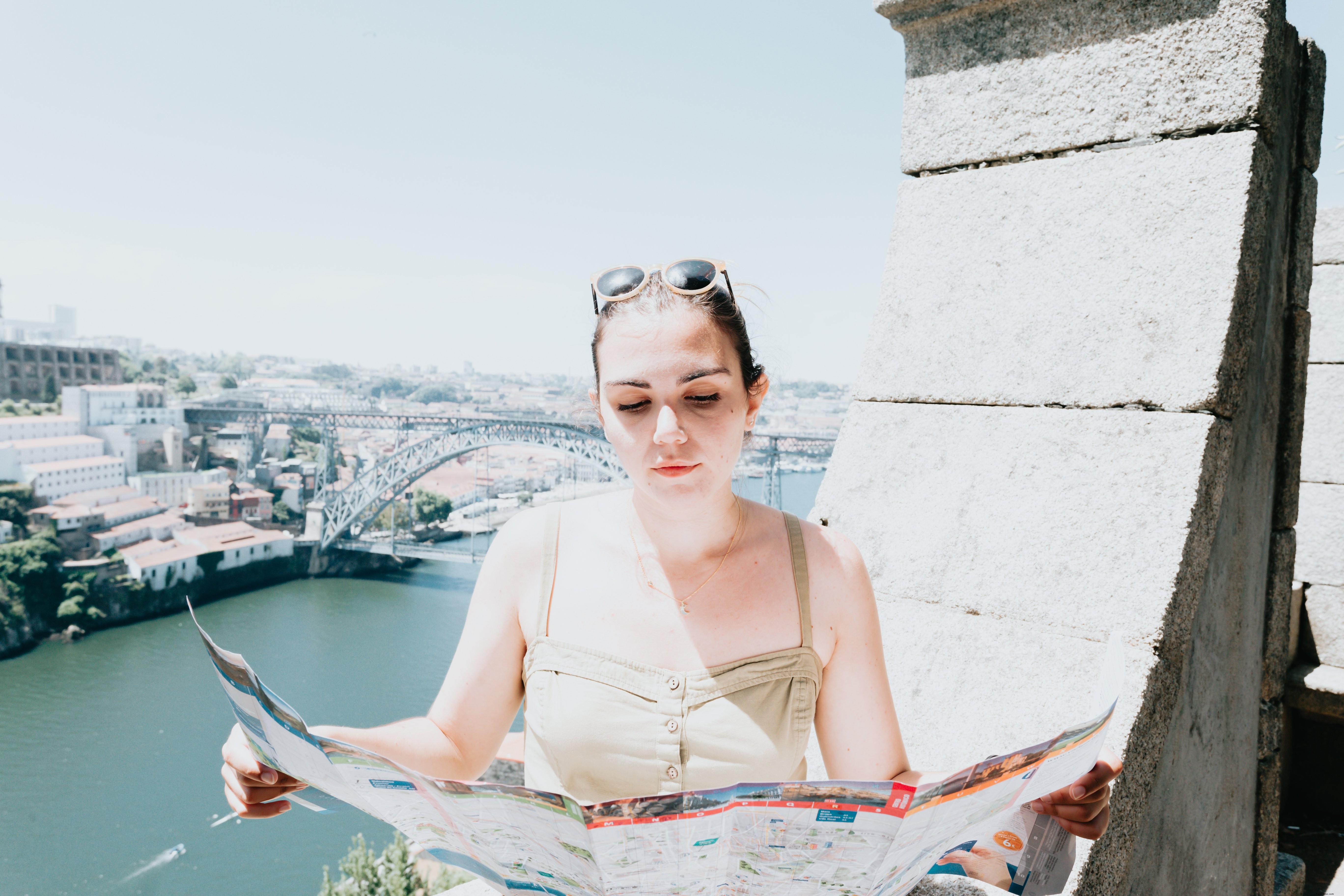 Mujer sostiene un mapa de la ciudad abierto con ambas manos y lo mira Foto 