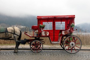 Une calèche rouge et blanche avec un cheval attaché à elle Photo 