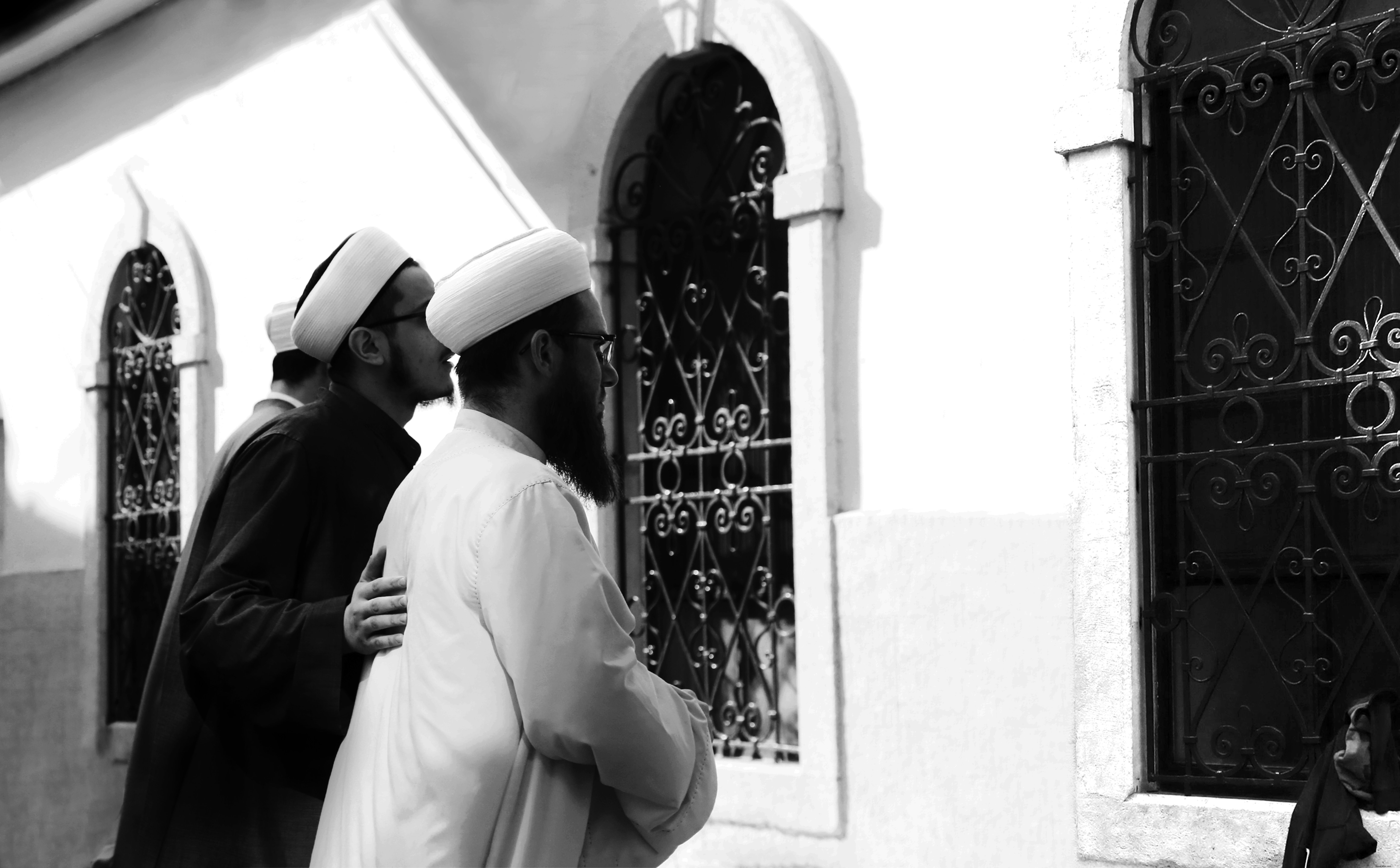 Fotografía en blanco y negro de dos personas mirando por una ventana Foto 