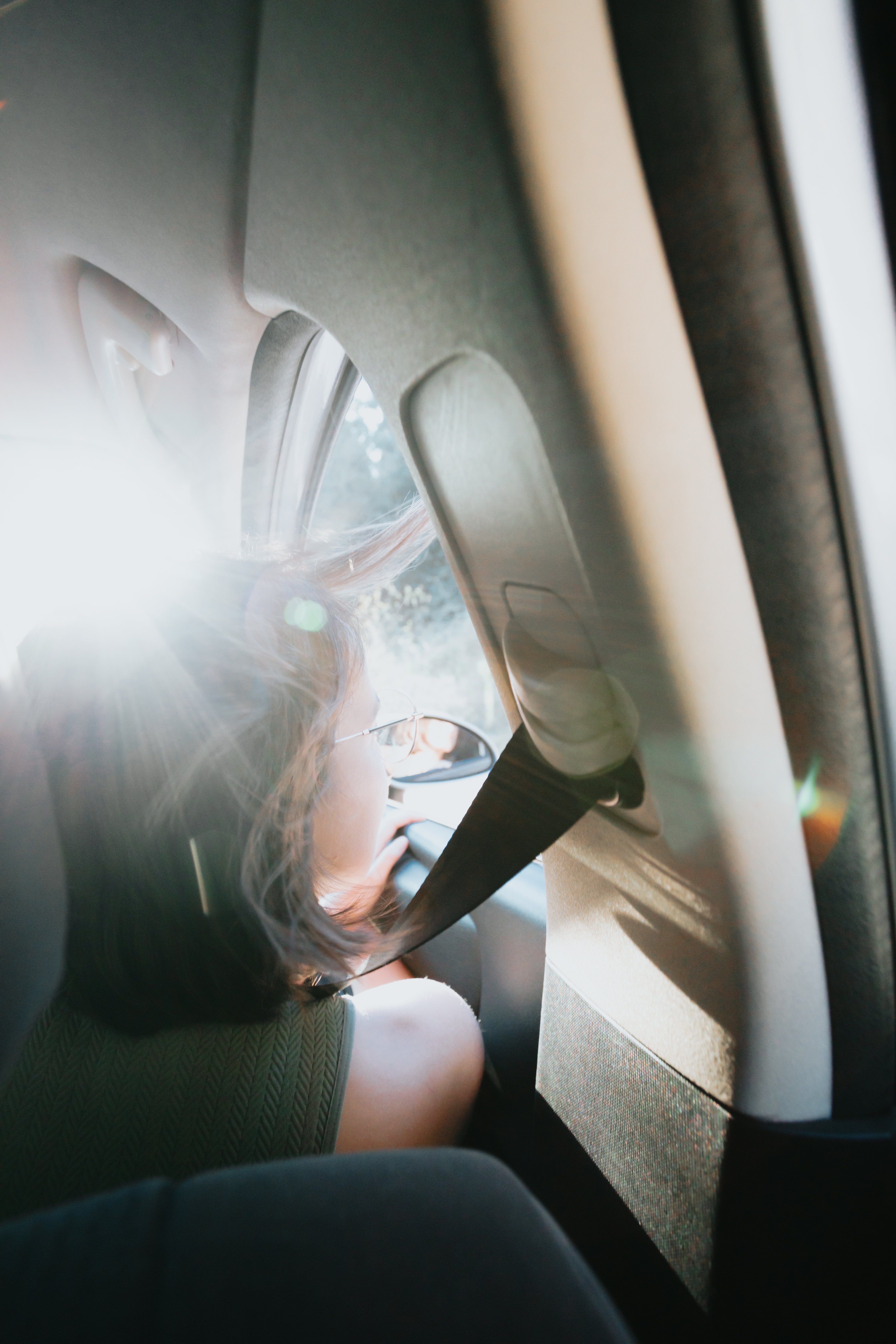 Persona mirando por la ventana del asiento delantero de una foto de coche 