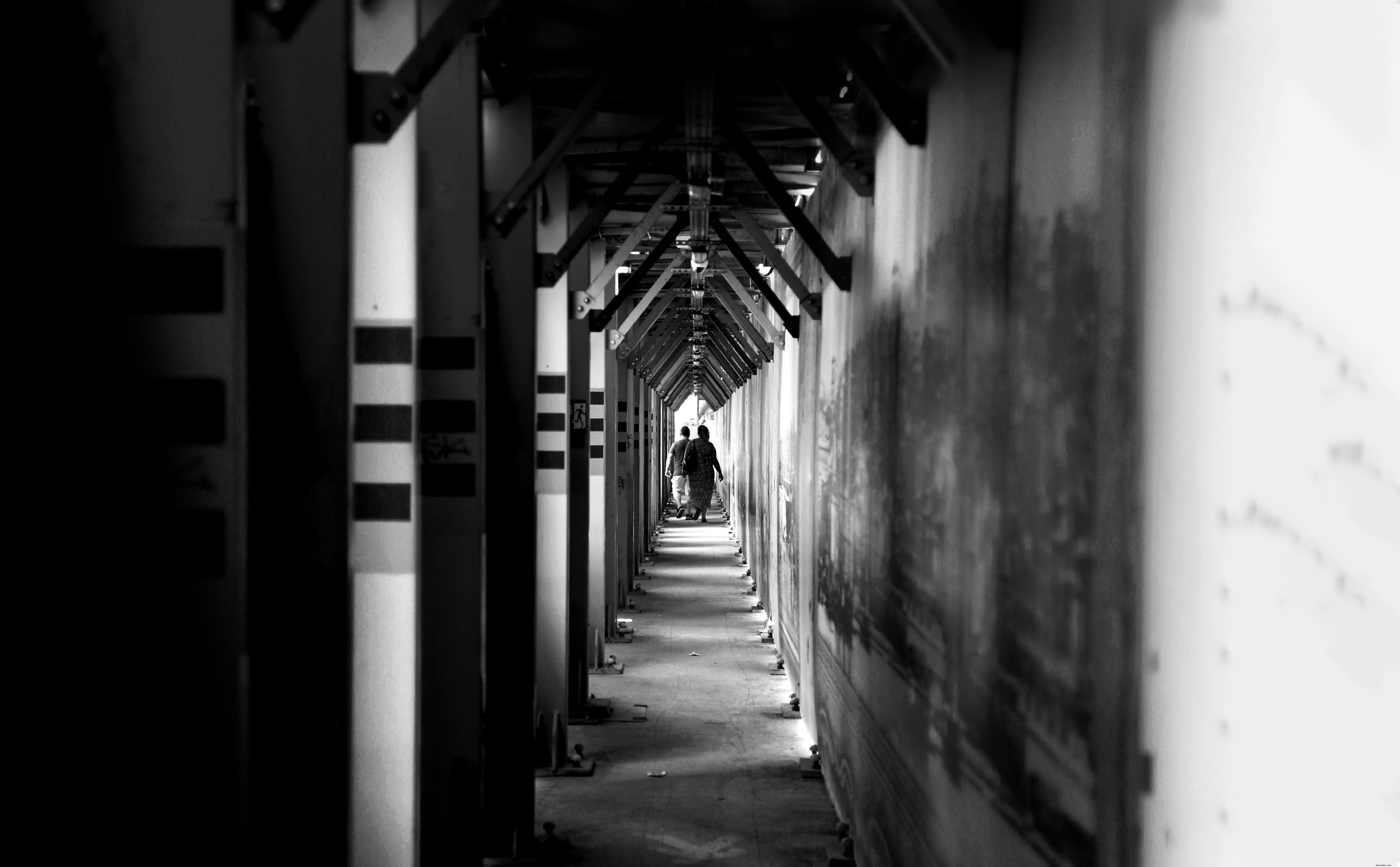 Dos personas caminan por una foto de un largo pasillo 
