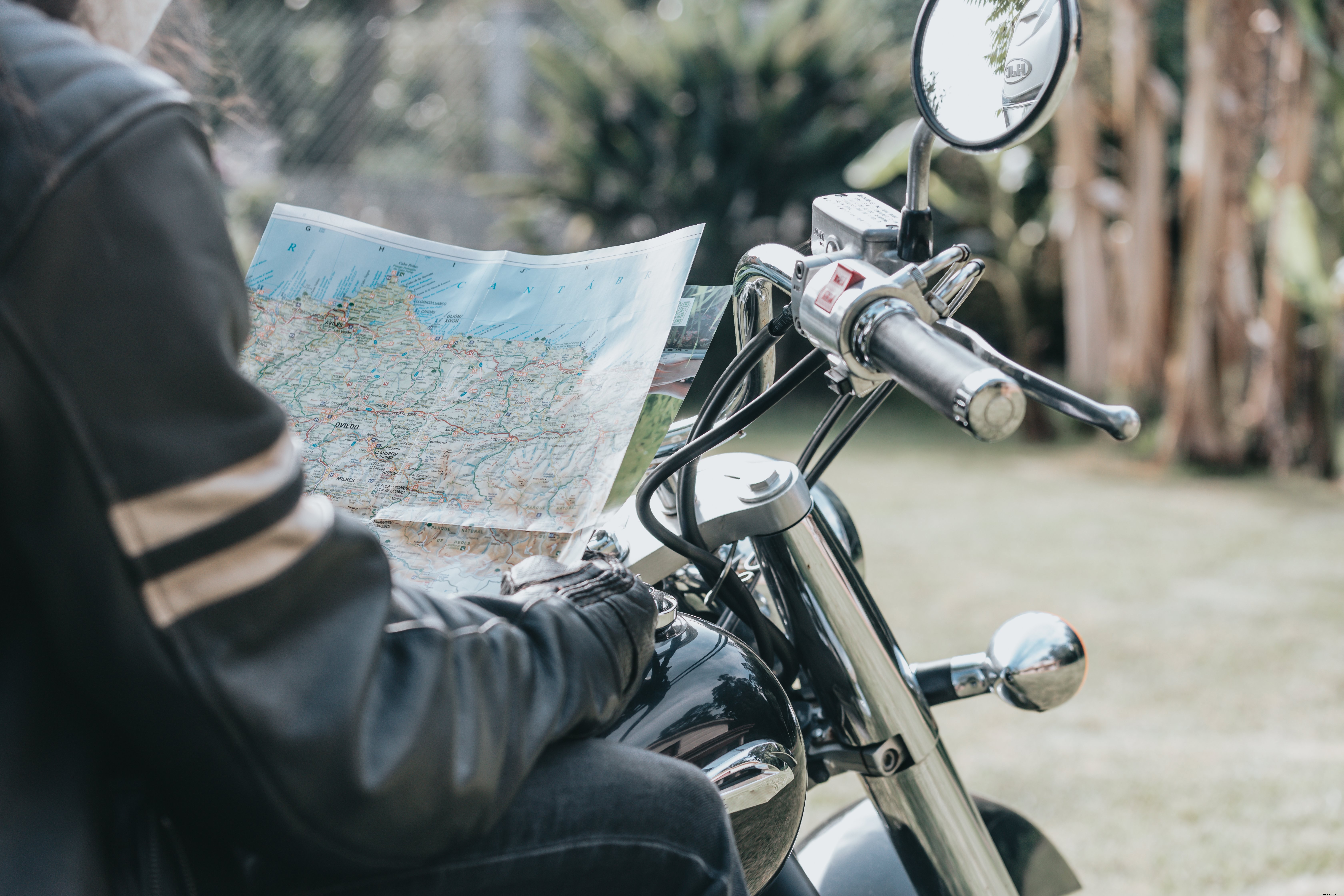 Pessoas no tronco em uma motocicleta segurando uma foto de mapa 