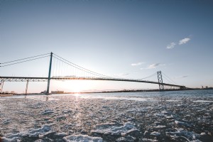 El sol se pone detrás de un largo puente de metal en invierno Foto 