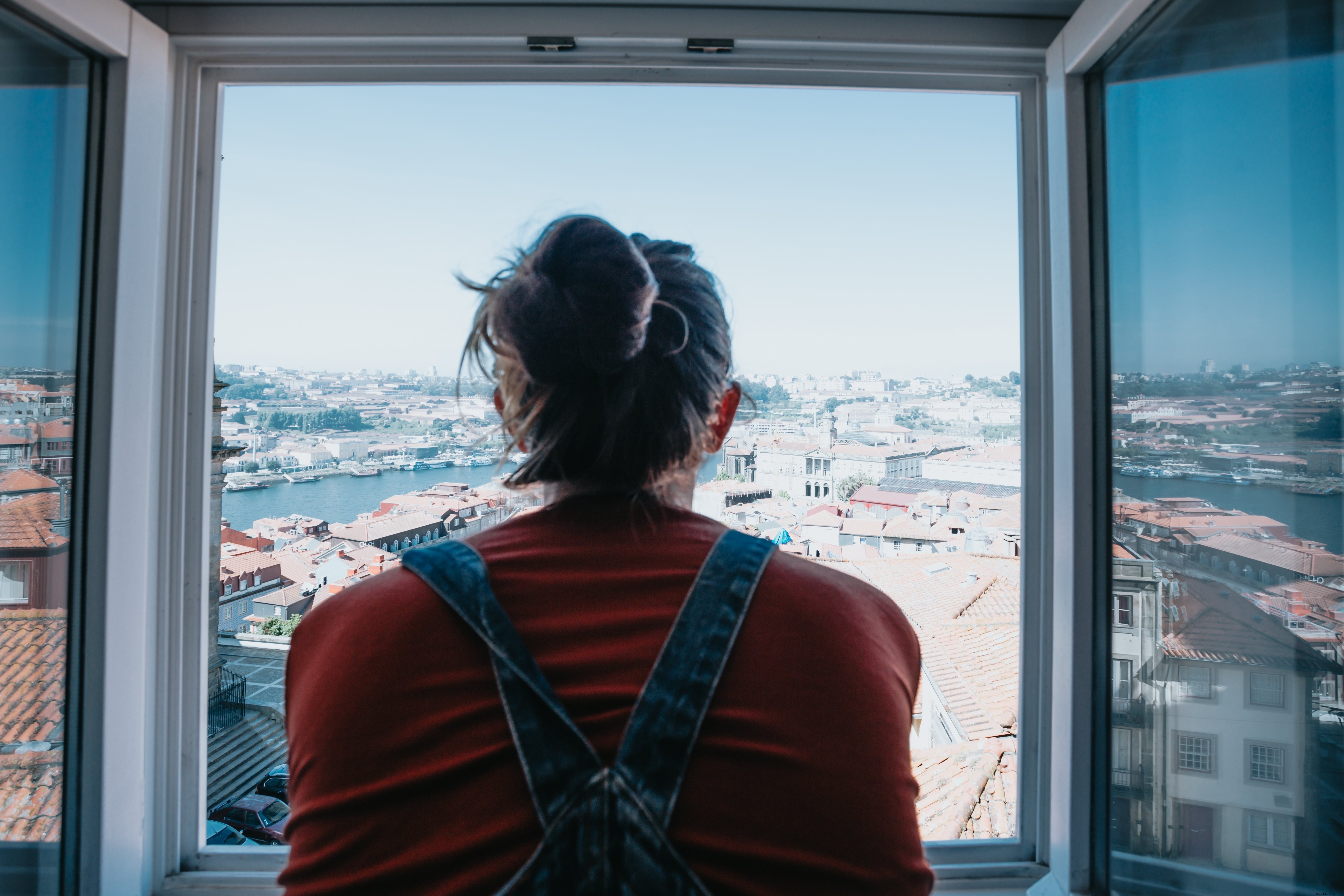 Personne regarde par la fenêtre ouverte sur la ville ci-dessous Photo 