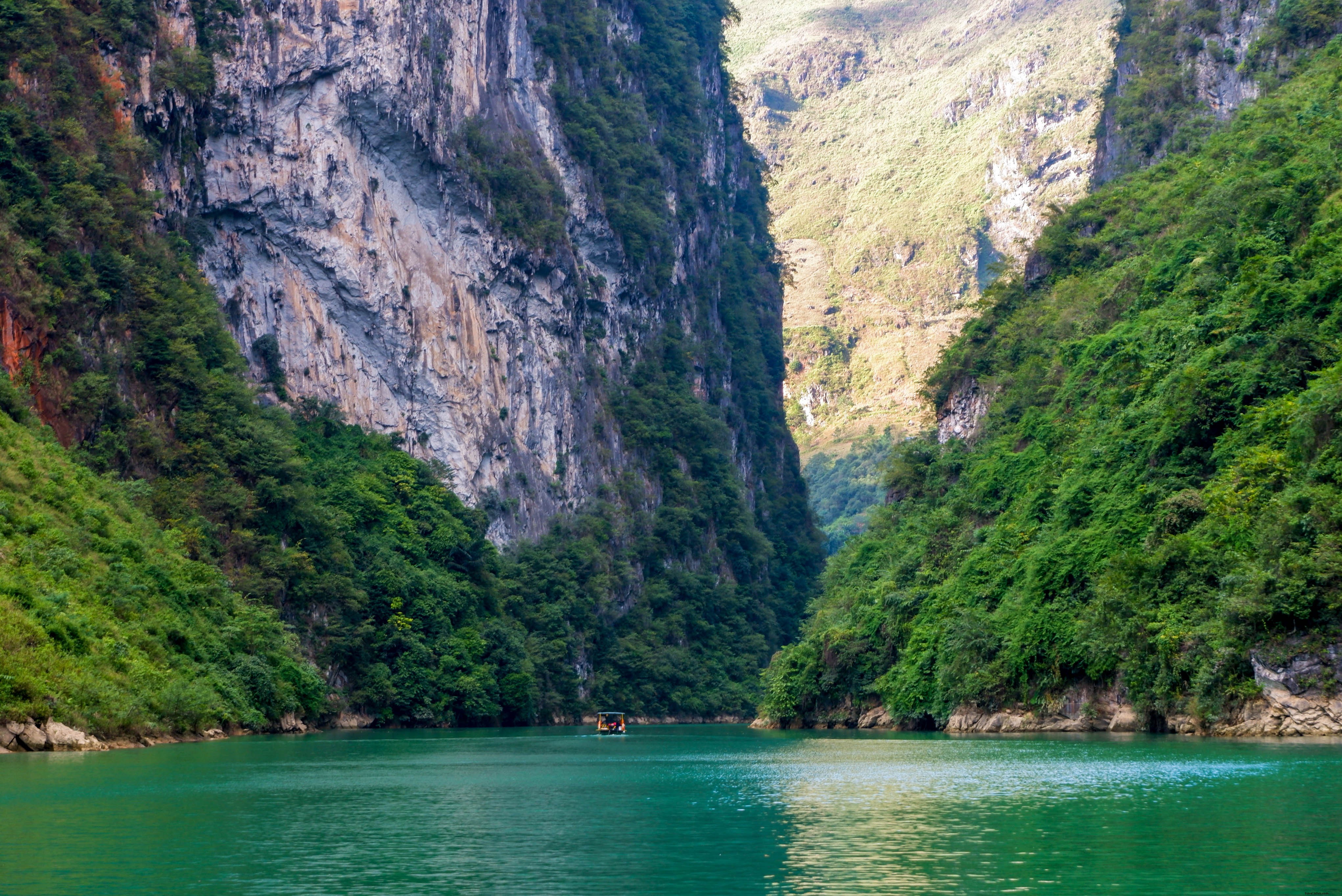 Acqua calma sotto una distesa di montagne verdi Foto 