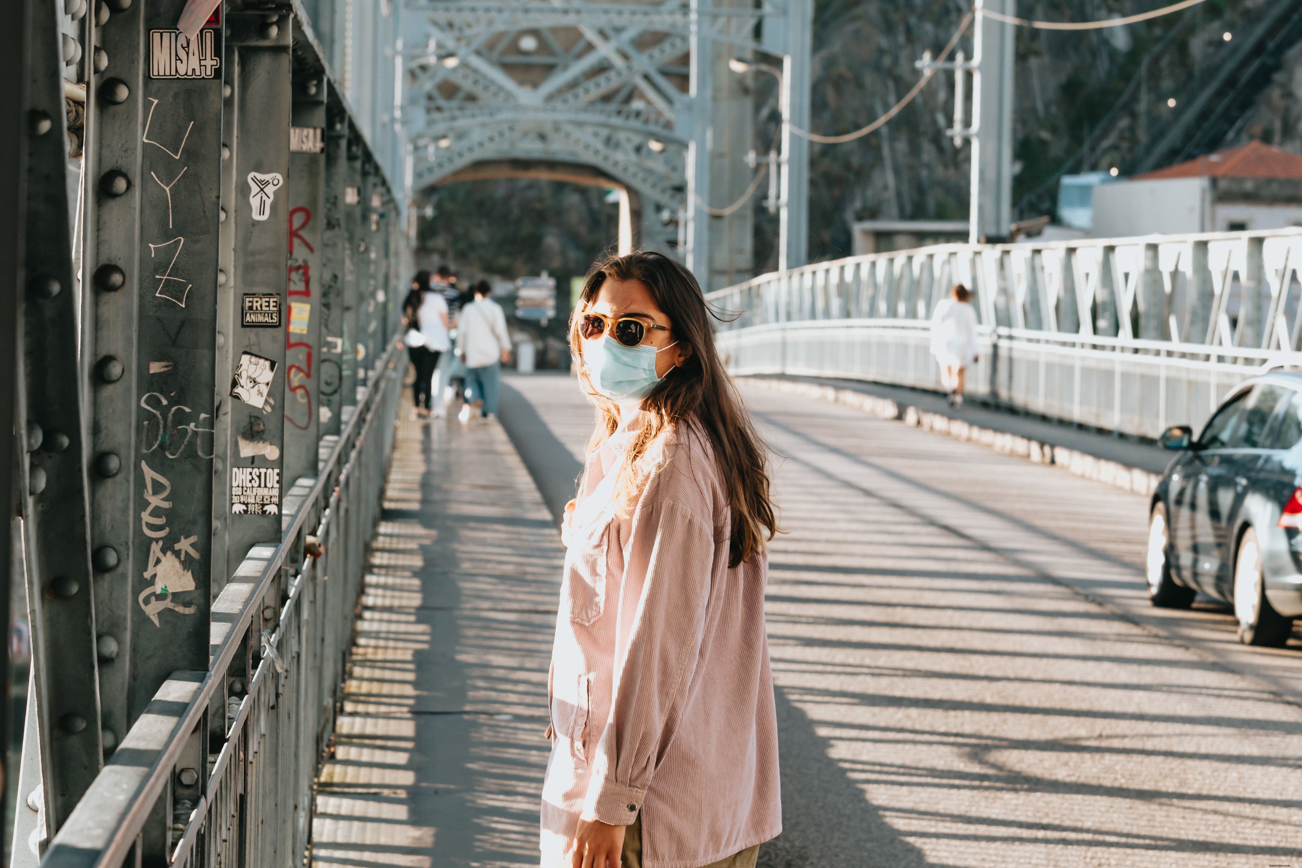 Foto di una donna su un ponte con una maschera facciale 