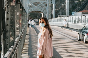 フェイスマスク写真の橋の上の女性 