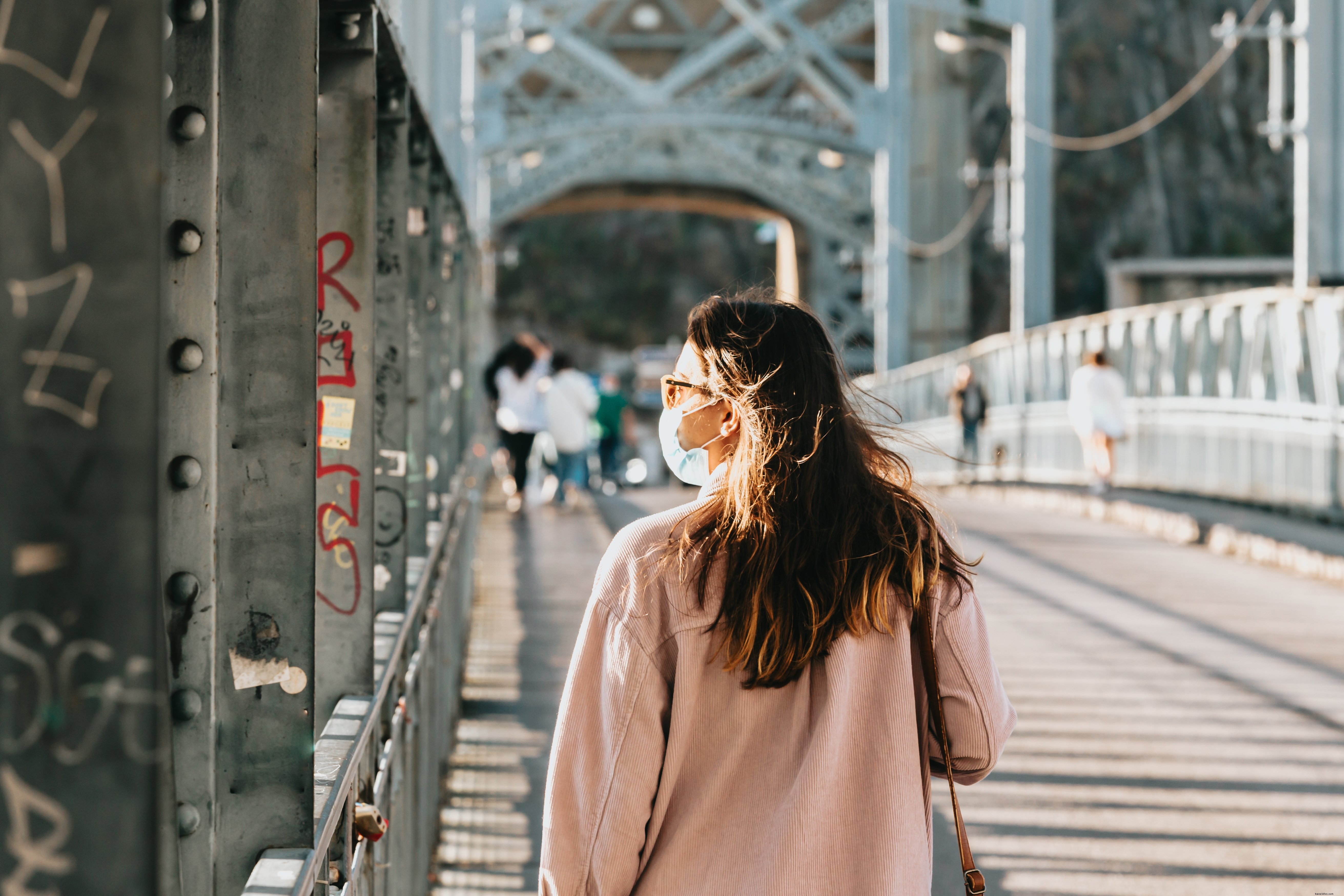 フェイスマスクの人が橋を渡って散歩写真 