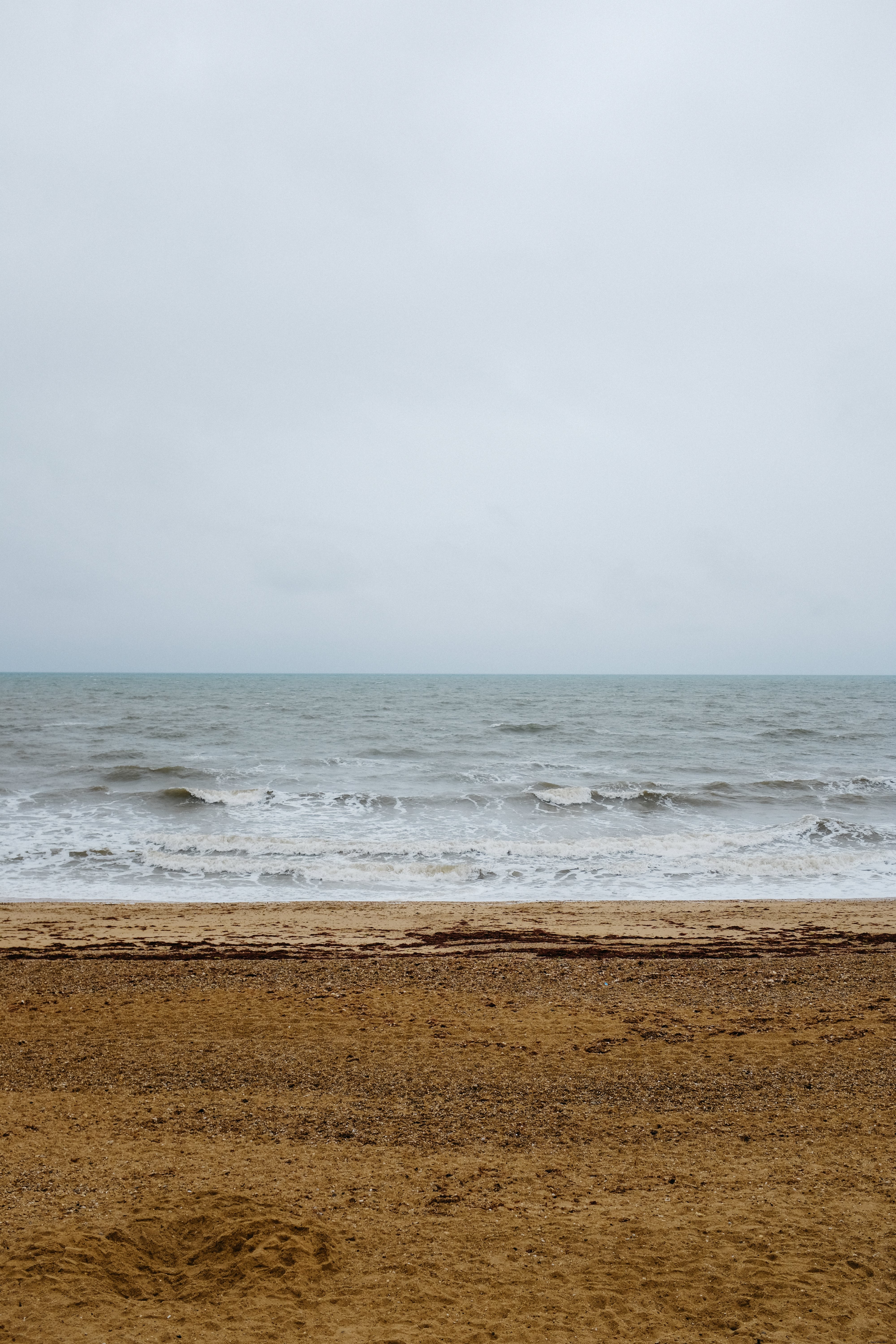 Foto Pantai Kosong Di Bawah Langit Mendung 